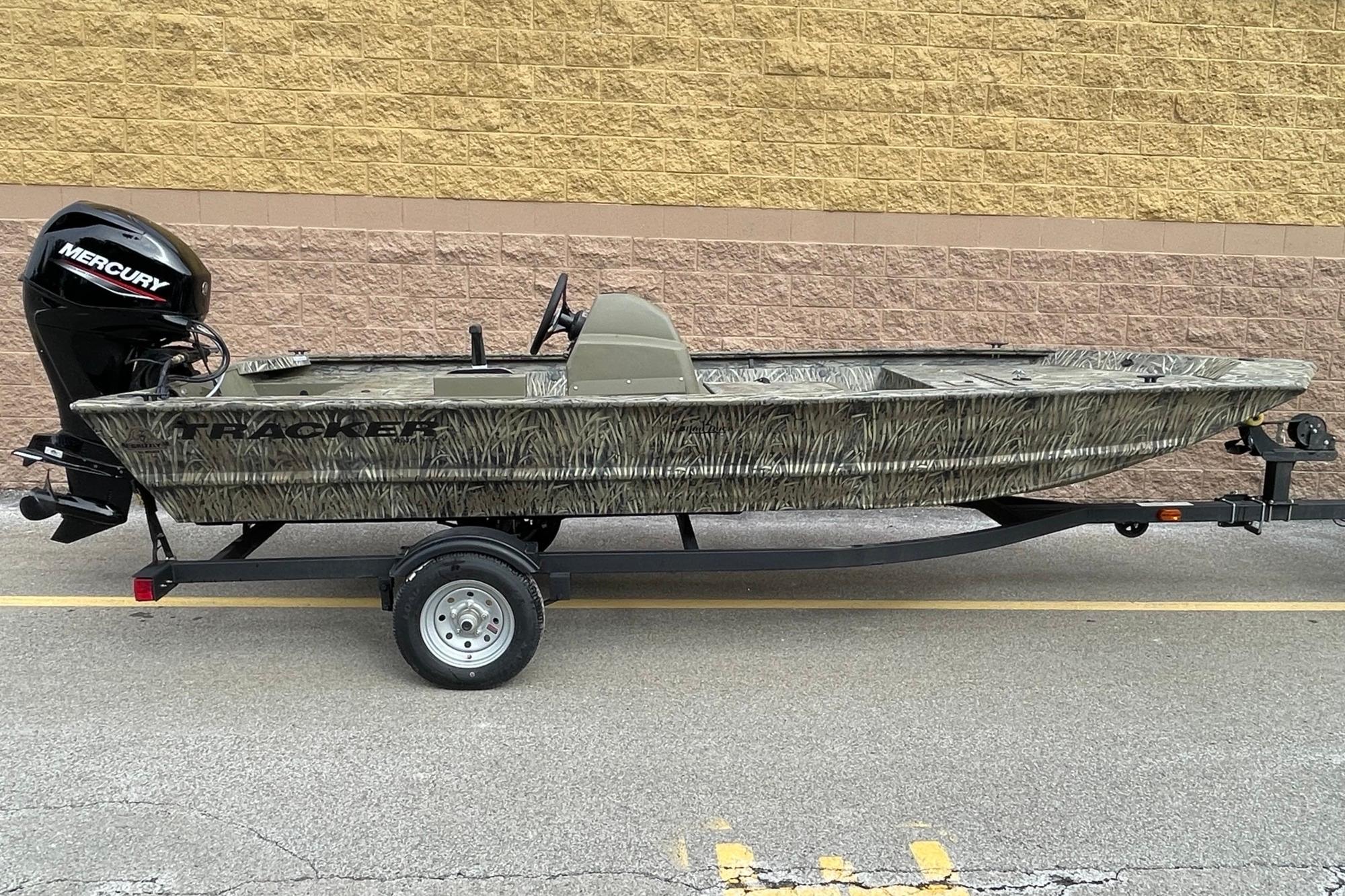 2026 Tracker Grizzly 1648 SC boat with Mercury engine on trailer, parked outdoors.