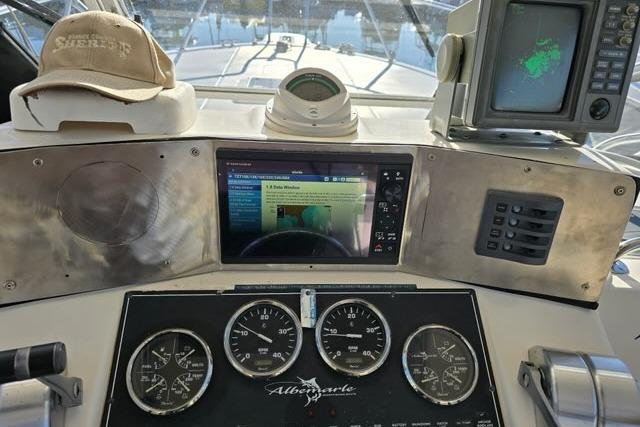 1999 Albemarle 305 Express Fisherman dashboard with gauges, navigation screens, and a sheriff hat.