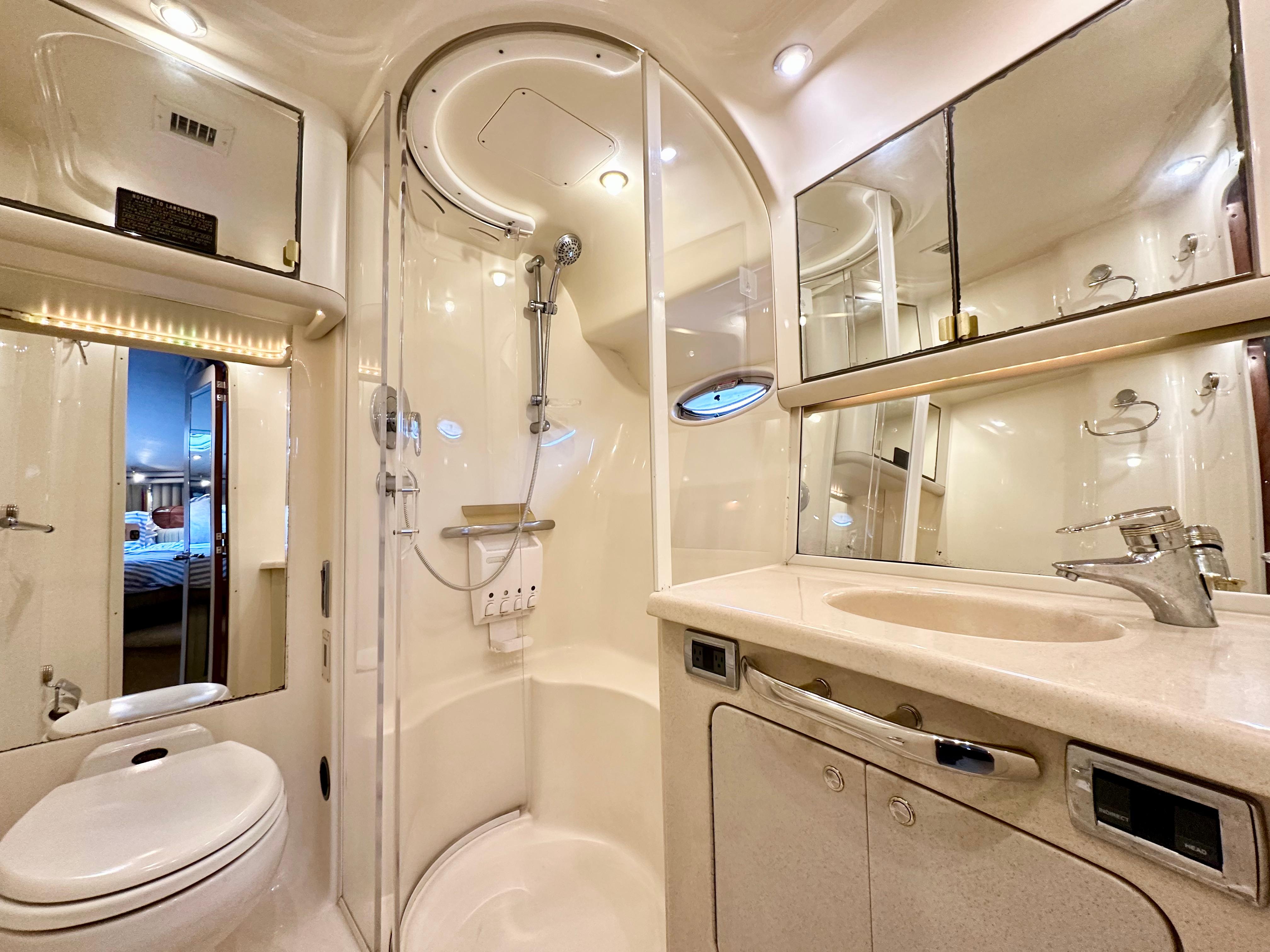 Luxurious bathroom in 2002 Sea Ray 560 Sedan Bridge yacht with shower, sink, and toilet.