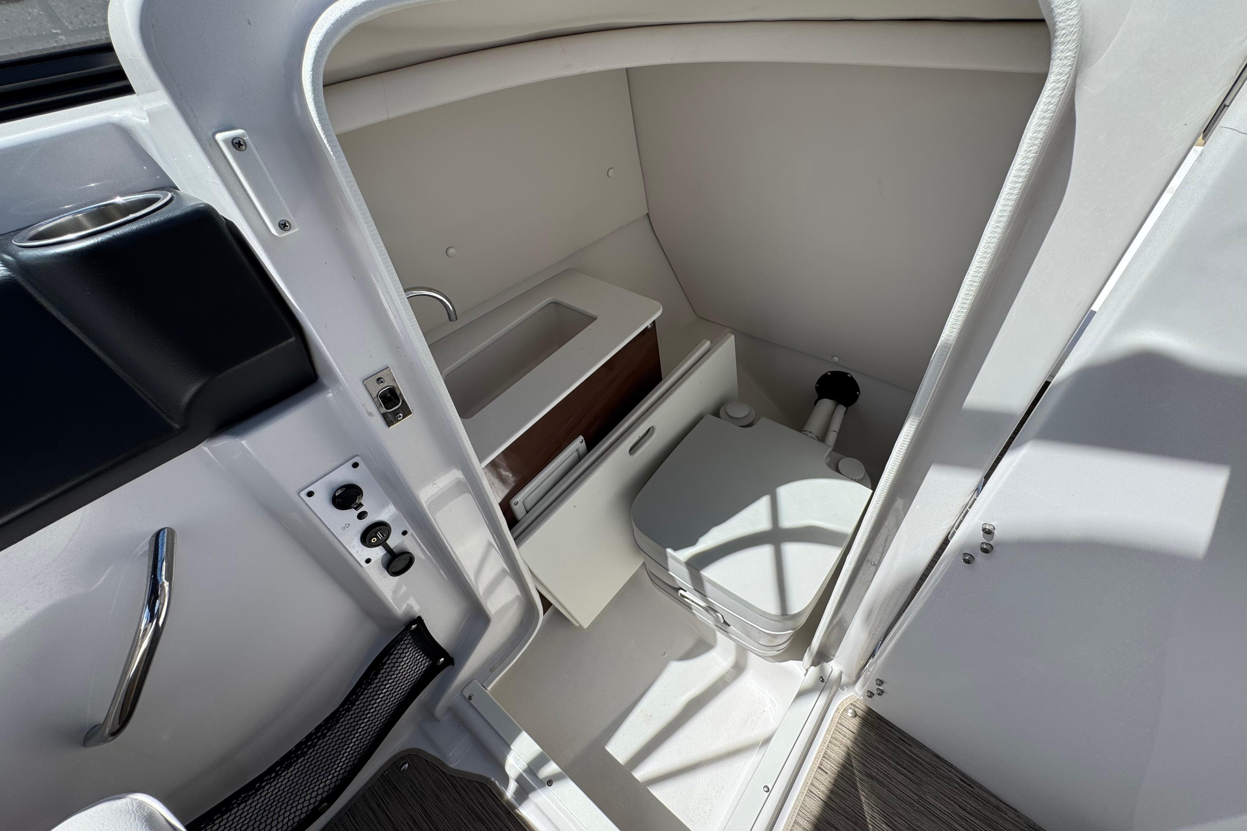 Interior of 2017 Scarab 255 H.O. Platinum boat featuring compact bathroom amenities.