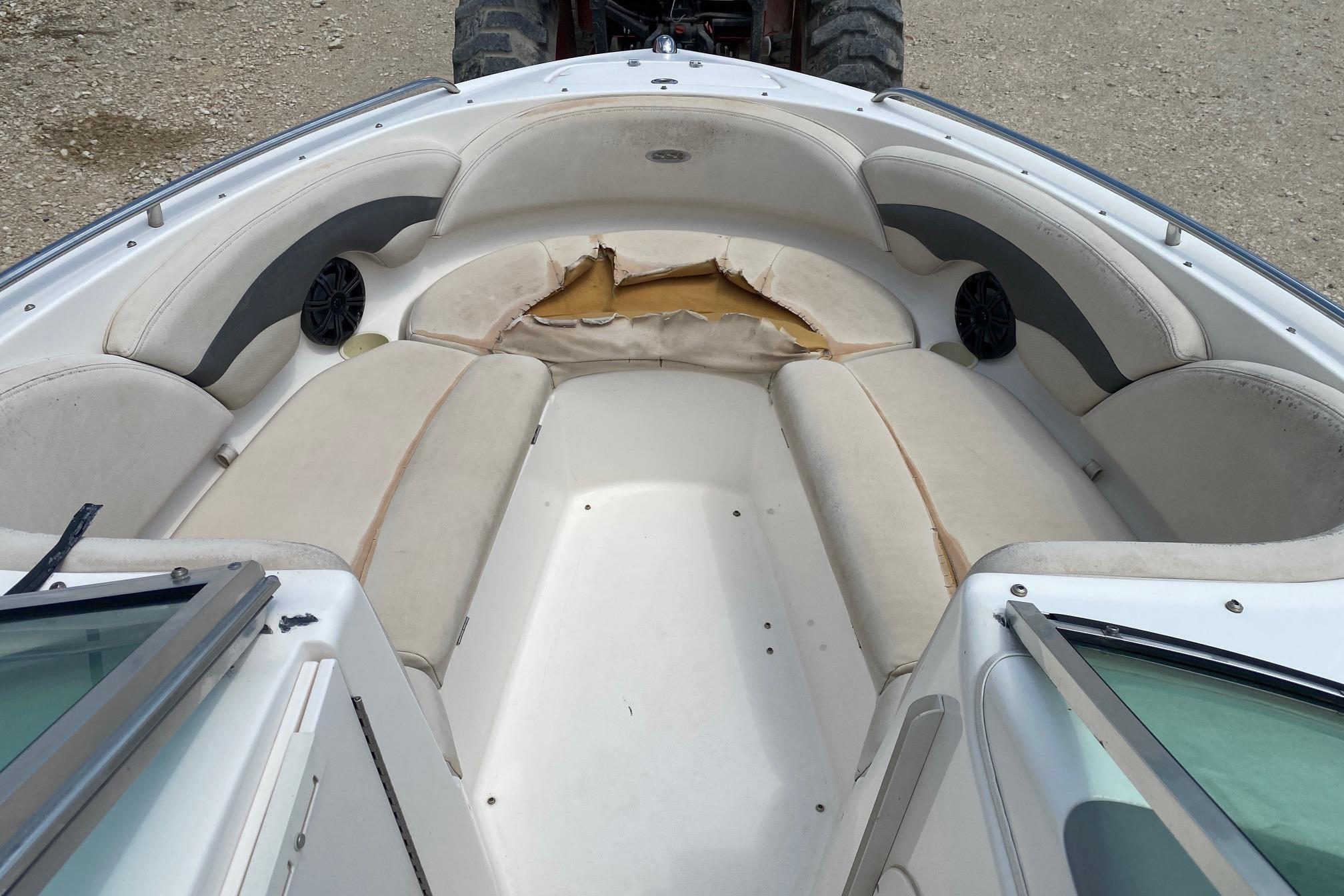 2004 Chaparral 230 SSi boat interior with worn seating and visible damage.