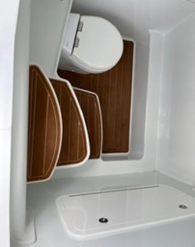 2022 Yellowfin 39 Offshore boat interior with wooden flooring and compact toilet.