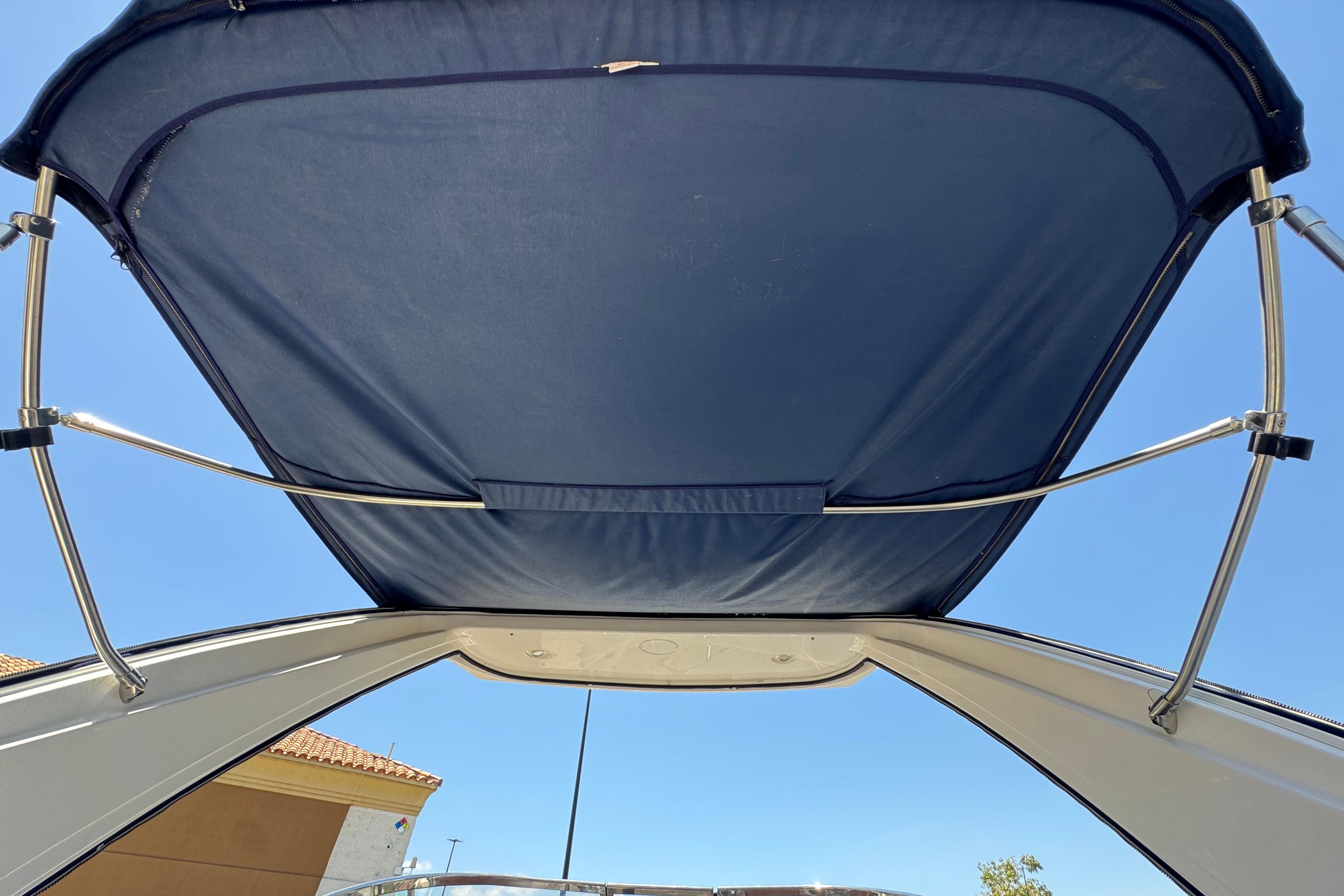 Bimini top of a 2013 Regal 28 Express boat against a clear blue sky.