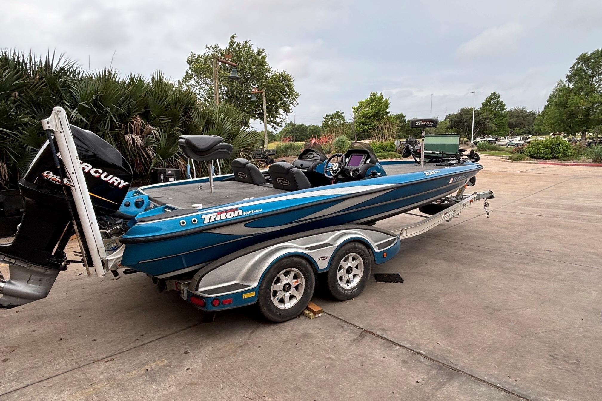 2009 Triton 22 TrX boat on trailer, parked outdoors with Mercury outboard motor.