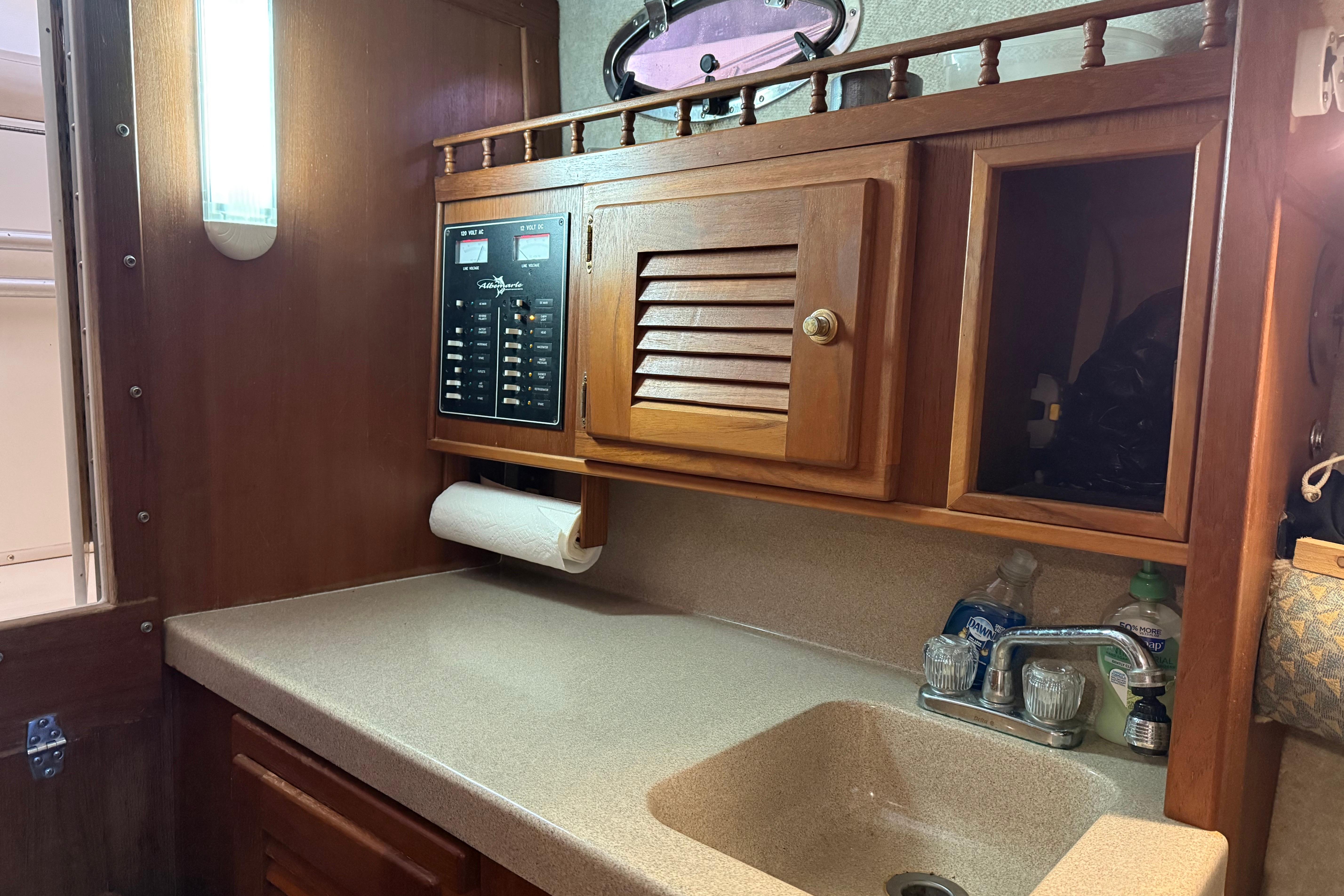 Interior of 2002 Albemarle 265 Express Fisherman with wooden cabinetry and sink.