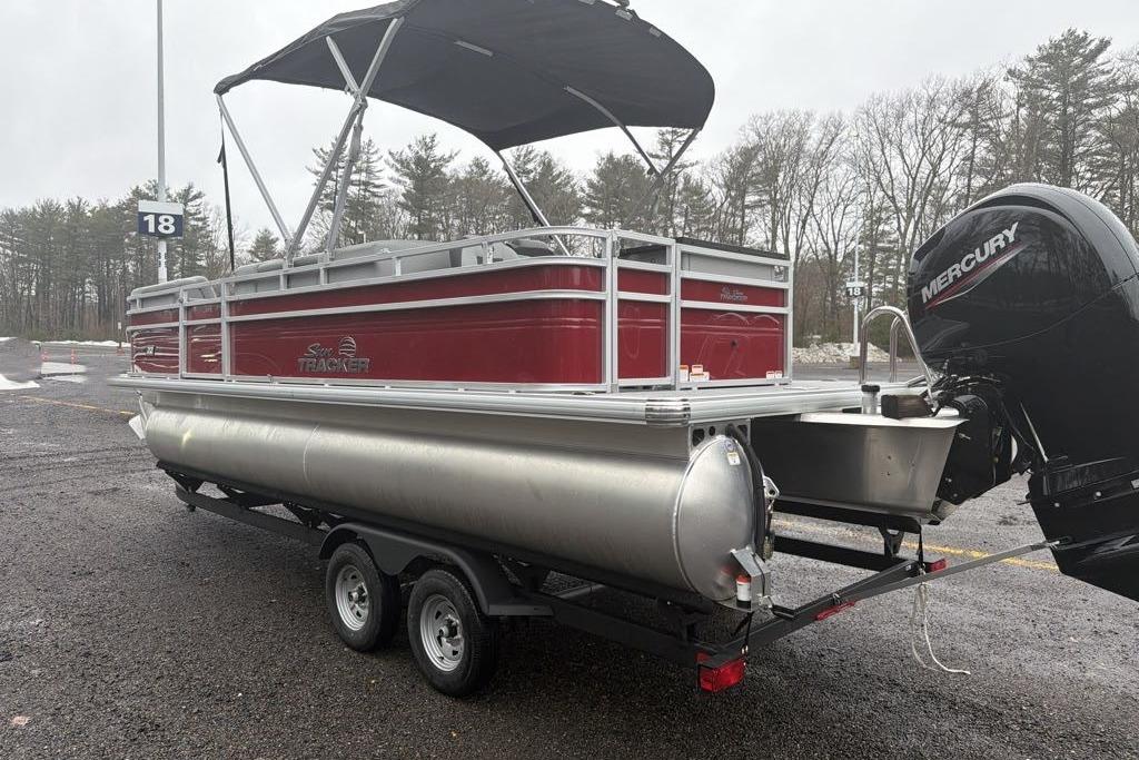 2026 Sun Tracker SportFish 22 DLX pontoon boat on trailer, featuring a Mercury outboard motor.