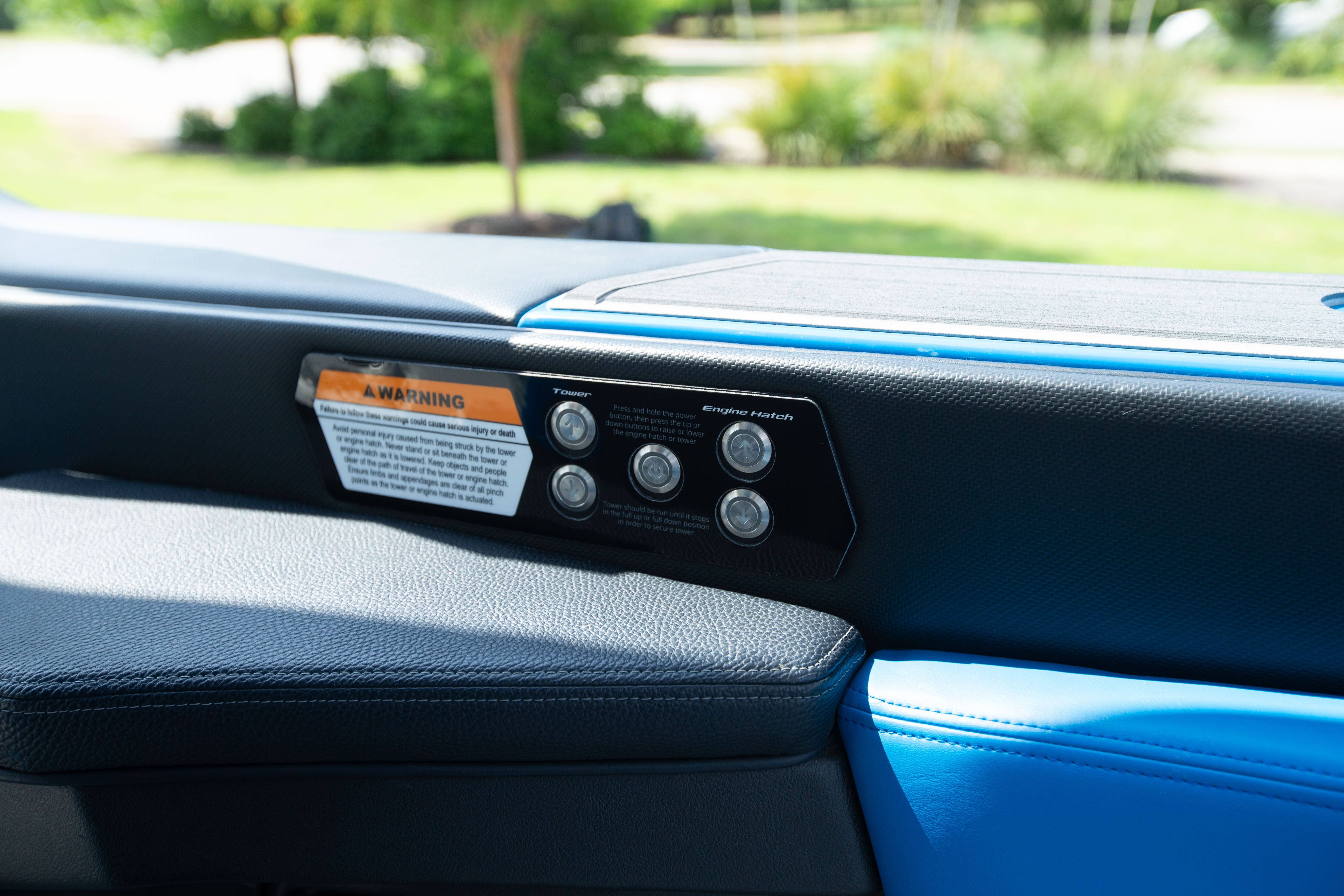 Close-up of a boat panel with warning label and buttons.