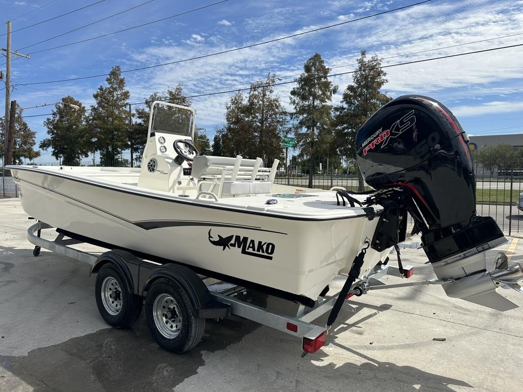 2024 Mako Pro Skiff 19 CC boat on trailer with Mercury engine, parked outdoors.