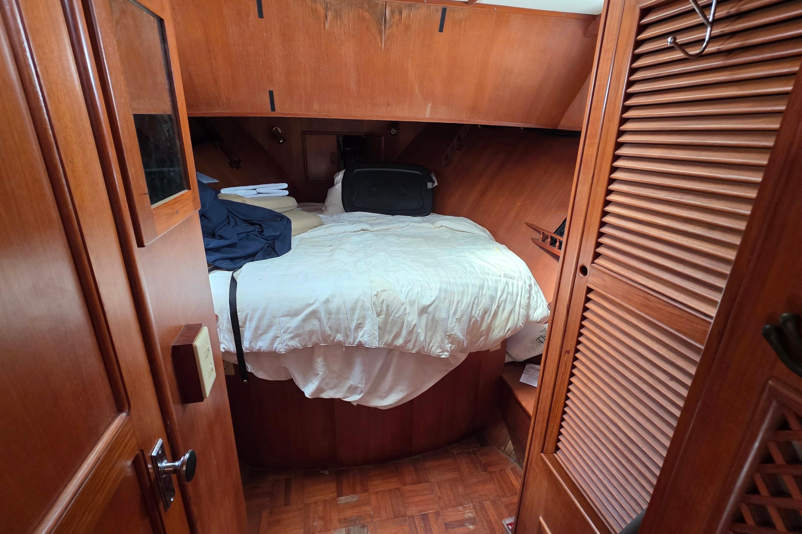Cozy cabin interior of a 1991 Marine Trader Trawler with wooden furnishings and a comfortable bed.