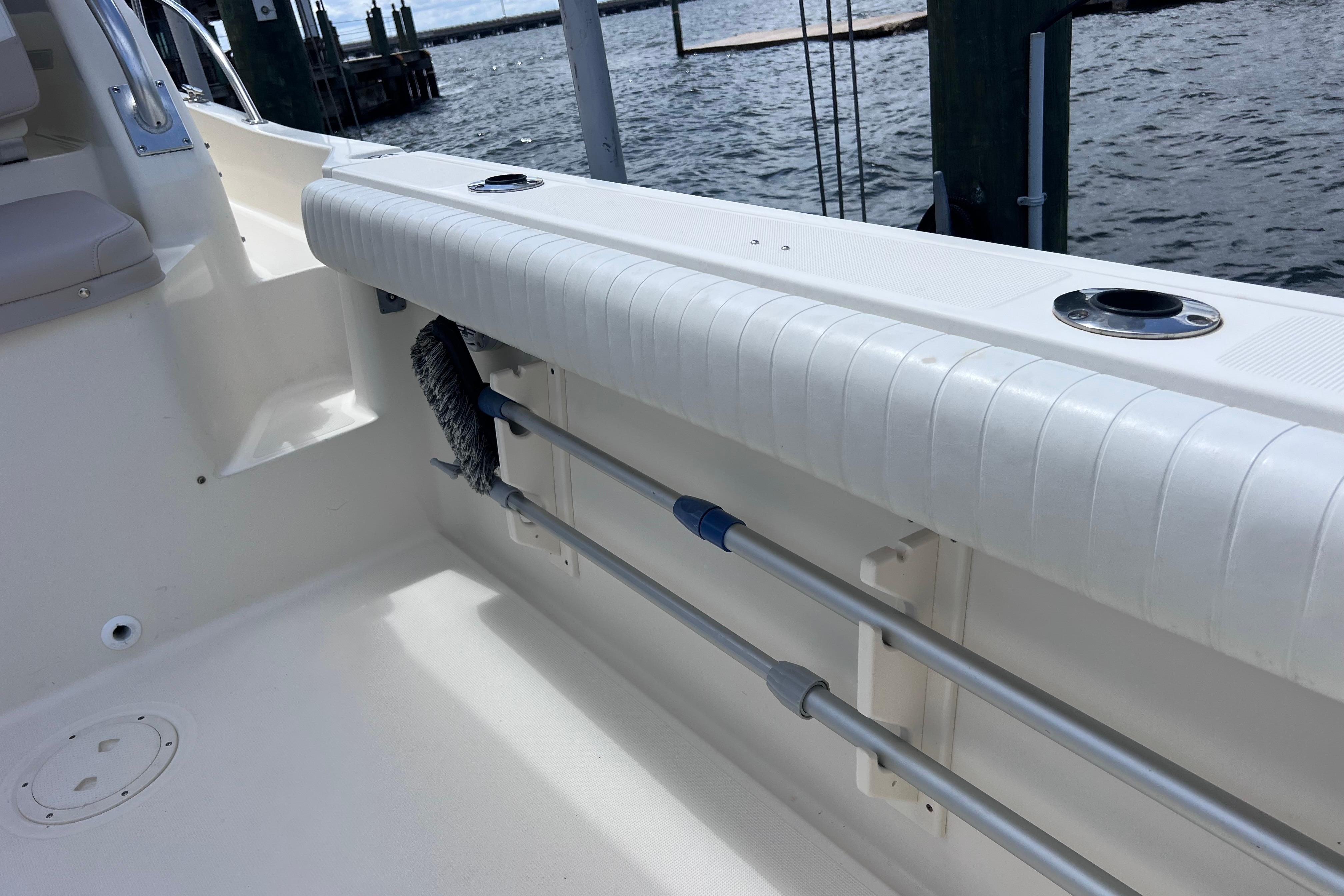 2004 Pursuit 2870 Walkaround boat interior with rod holders and cleaning brush.