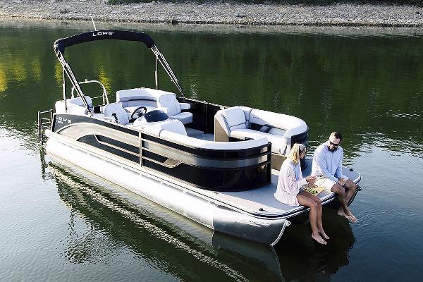 Manufacturer Provided Image: 2025 Lowe SS 230 WV pontoon boat on calm water with two people relaxing.