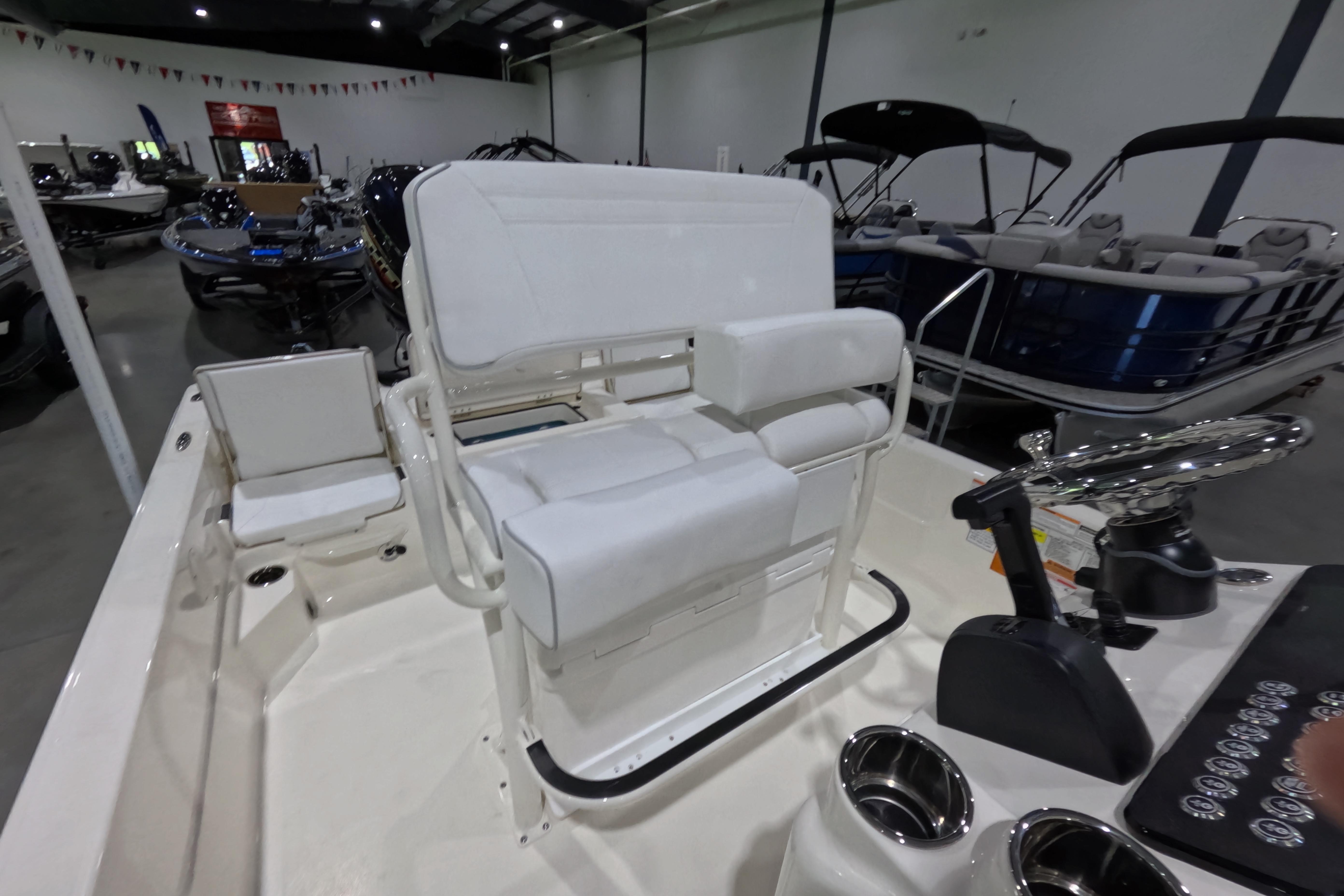 2026 Skeeter SX230 boat interior with white seating and control panel in showroom.