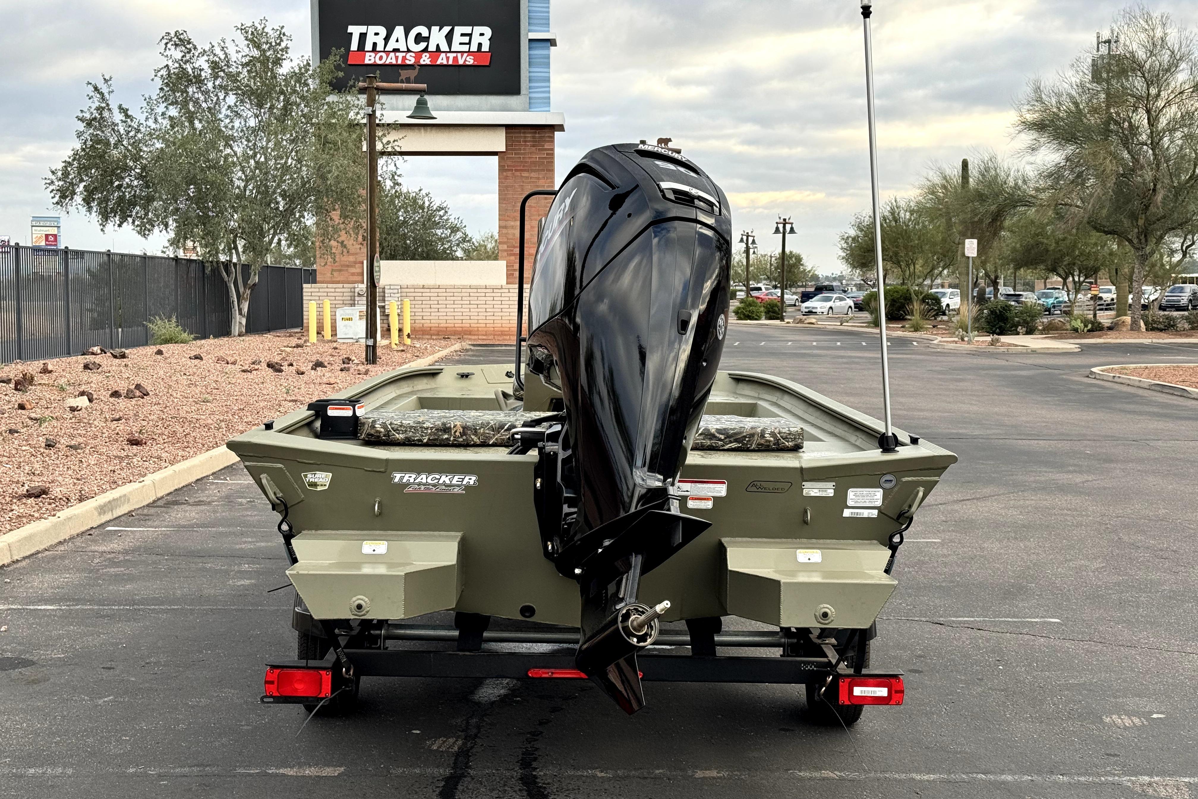 2025 Tracker Grizzly 1860 CC boat on trailer in parking lot.