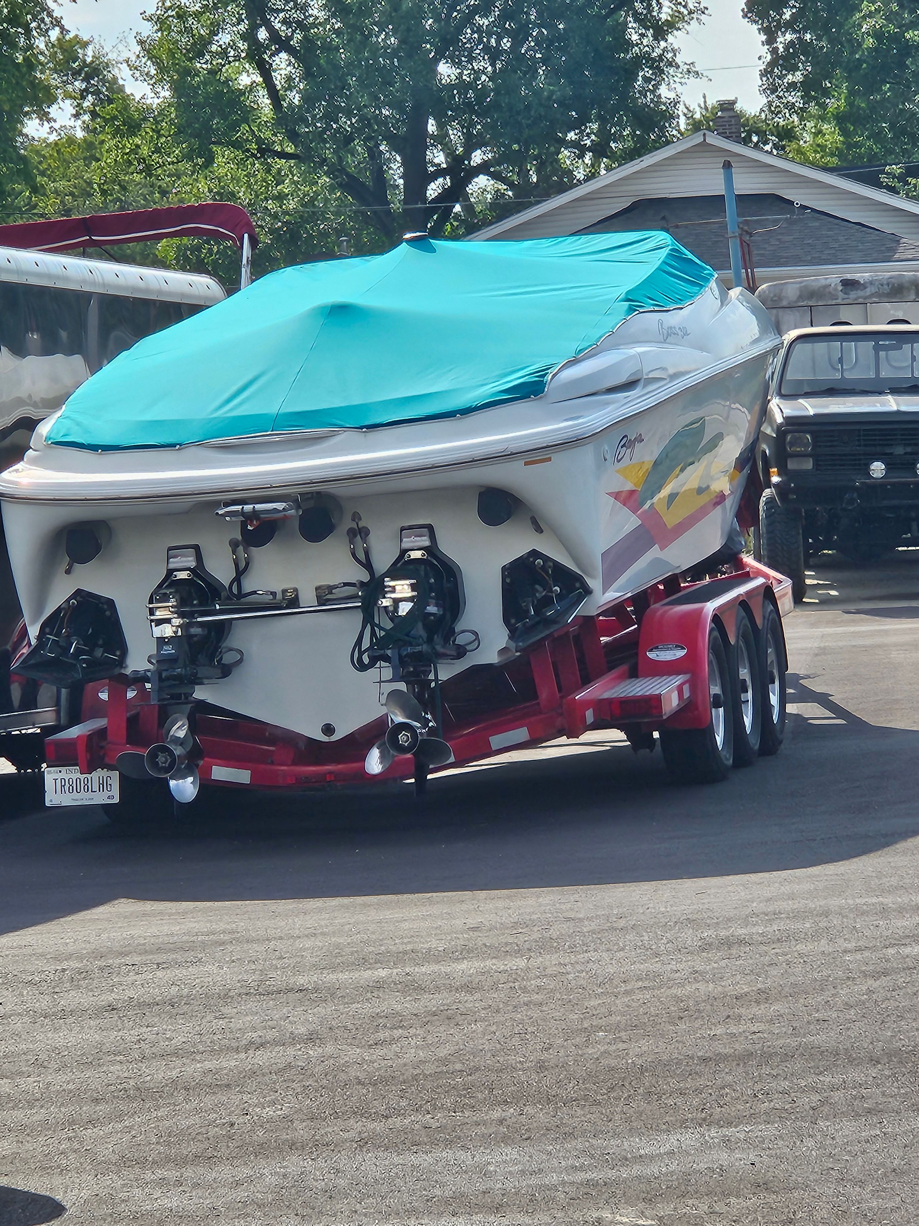 A 1996 Baja 302 Boss on a red trailer, covered with a blue tarp.