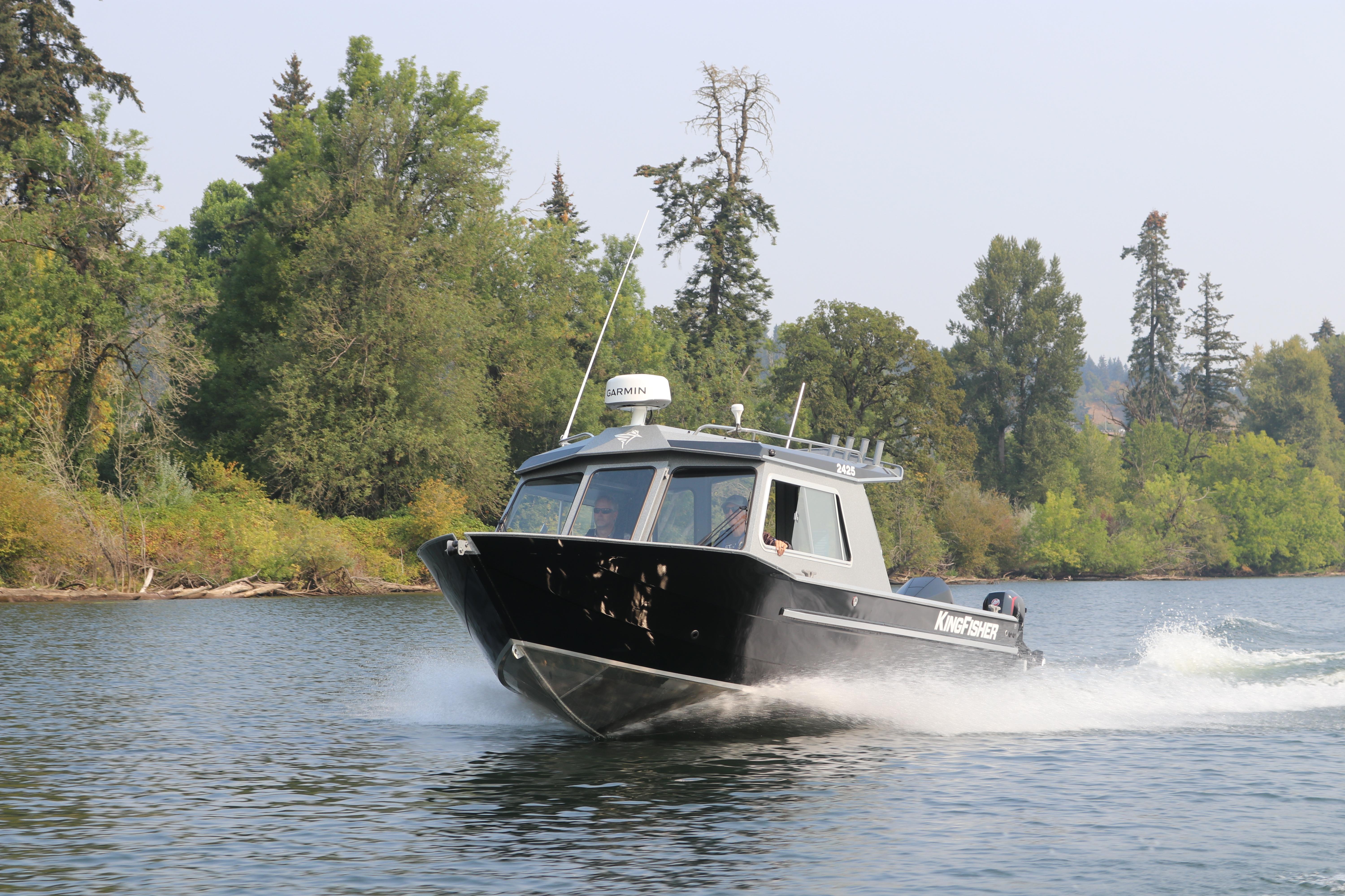 2026 KingFisher 2425 Escape HT boat cruising on a scenic river.