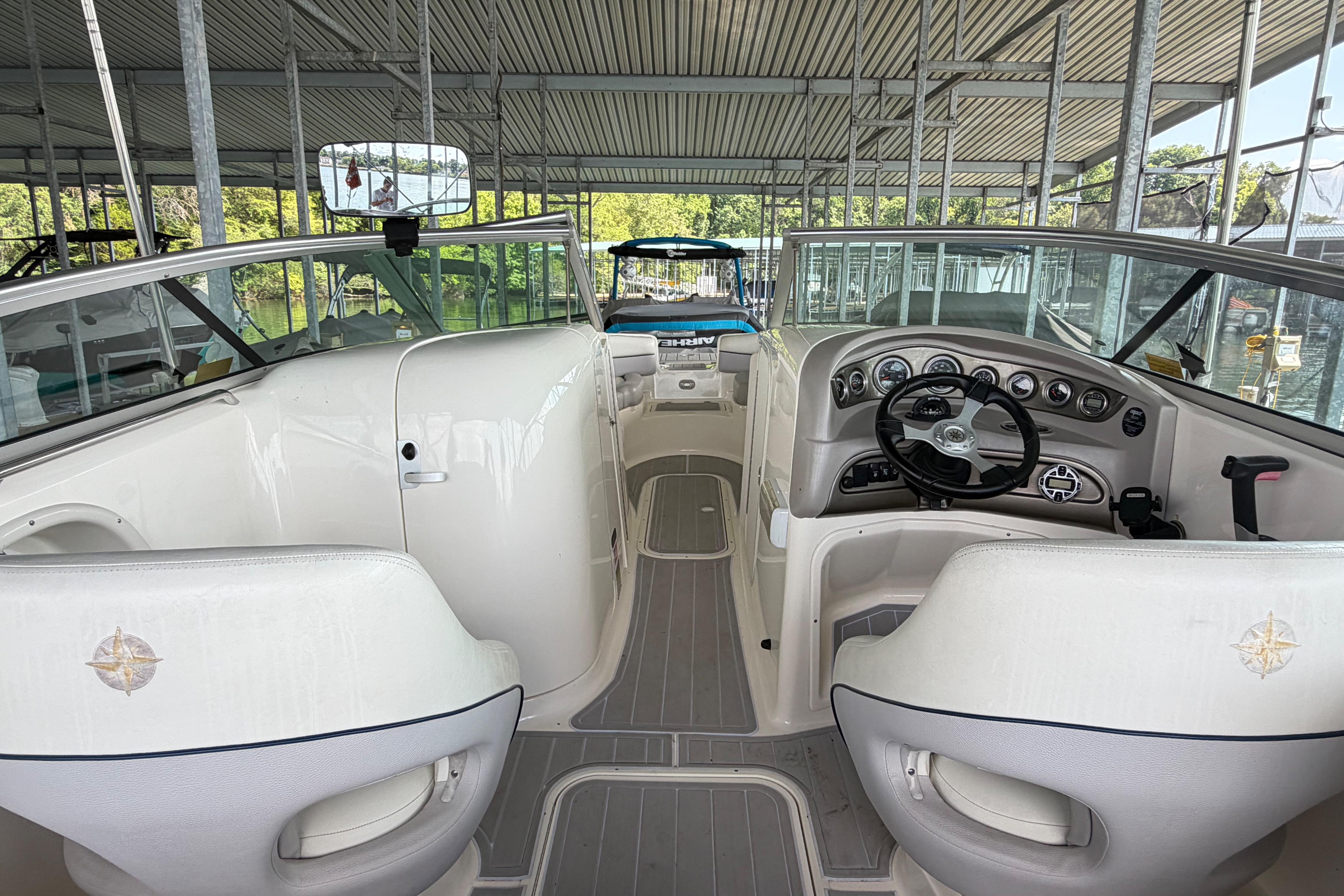Interior view of a 2010 Bryant 255 boat, showcasing steering and seating area.