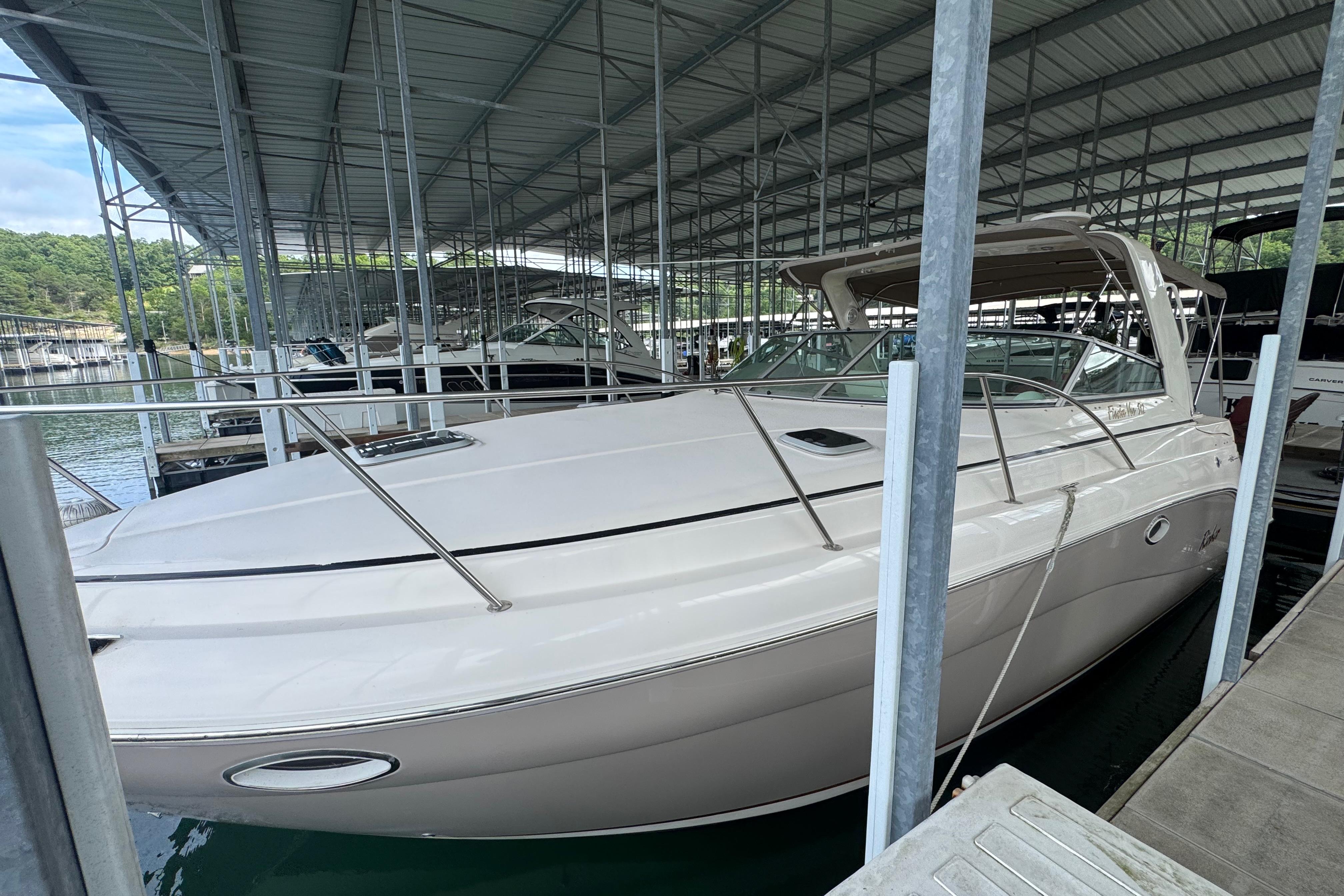 2004 Rinker Fiesta Vee 312 boat docked in a covered marina.