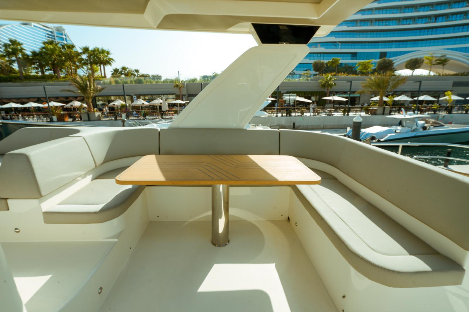 Luxurious seating area on 2024 Absolute NAVETTA 52 yacht with elegant wooden table.
