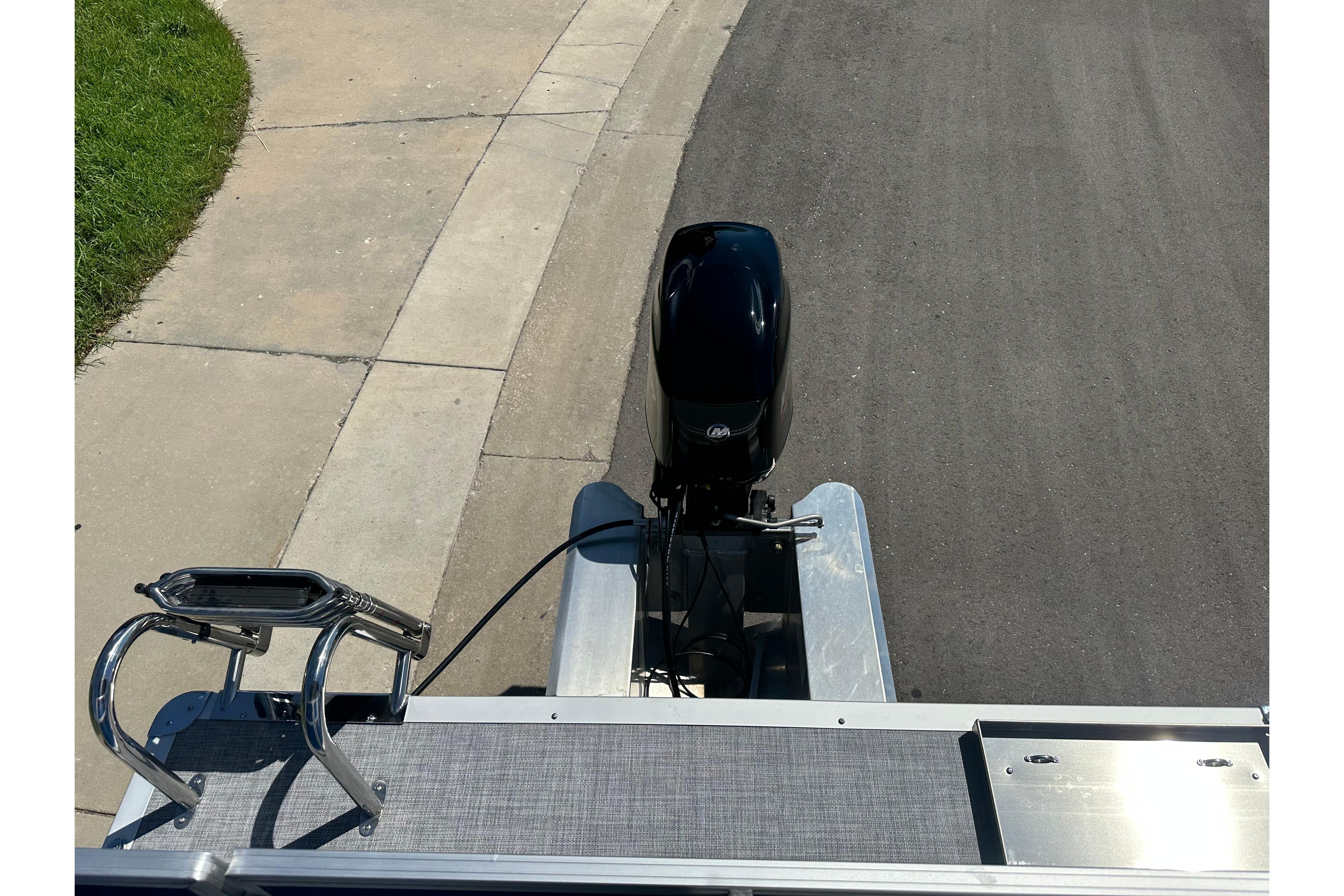 2026 Sun Tracker Party Barge 16 DLX pontoon boat with motor, parked on pavement.