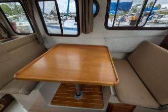 Interior of 2008 Ranger 25 with wooden table and seating.