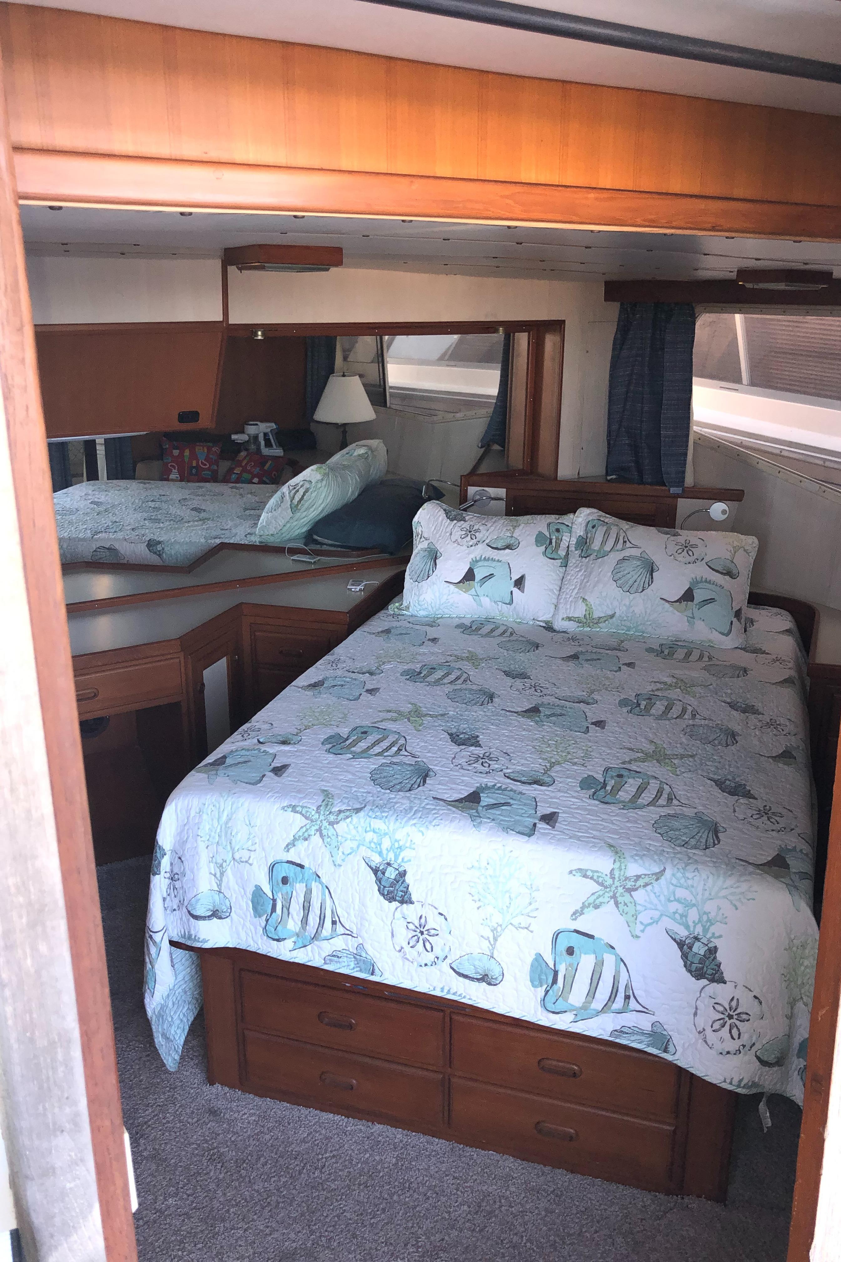 1987 Kadey-Krogen Silhouette bedroom with nautical-themed bedding and wooden furnishings.