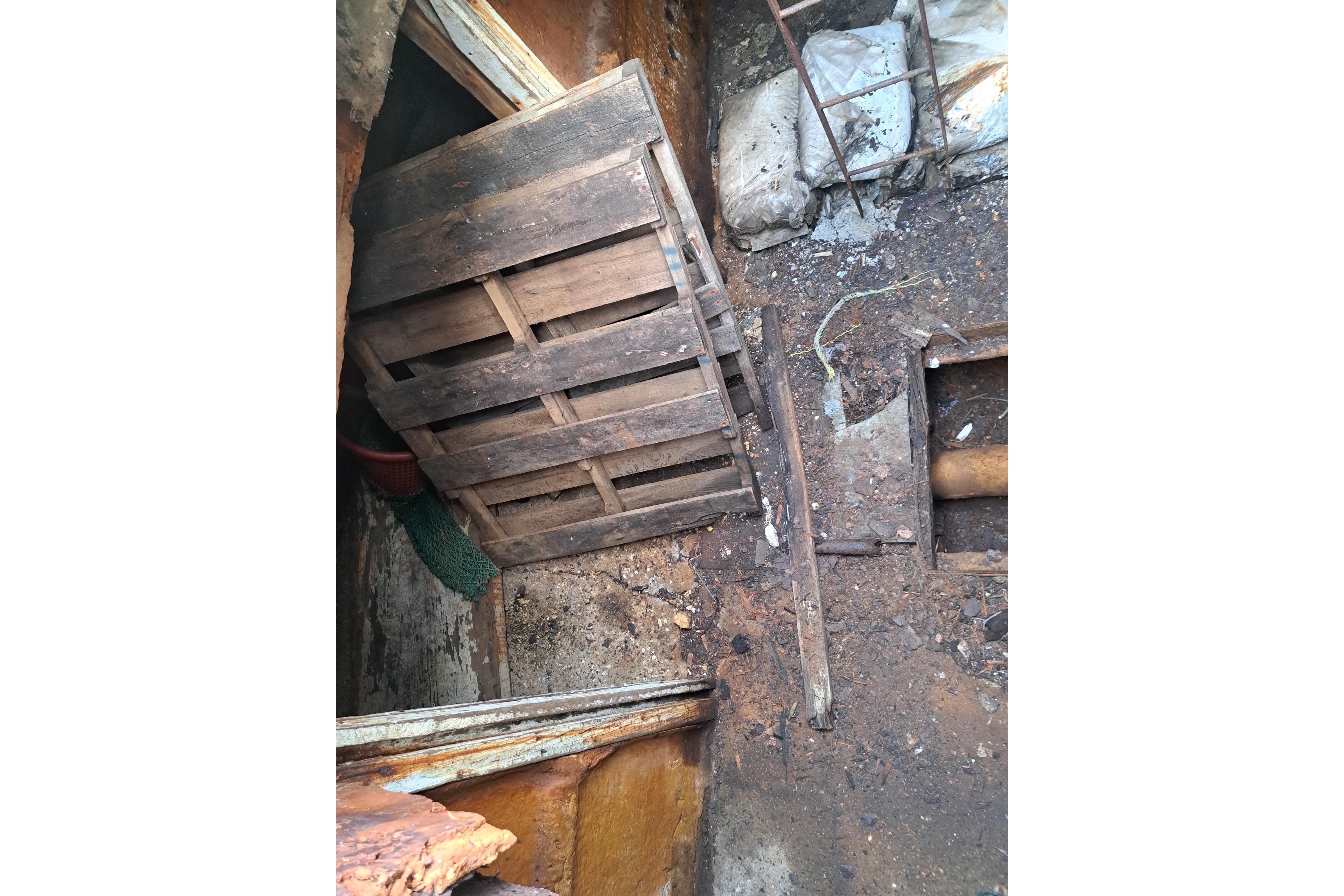 Interior of a 1979 Custom Steel Trawler Dragger with wooden pallets and debris.