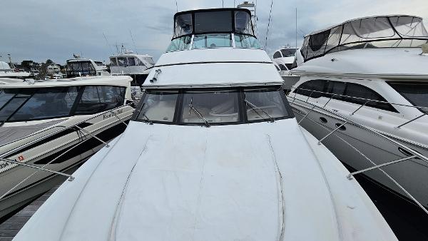 2000 Carver 450 Voyager Pilothouse yacht docked among other boats.