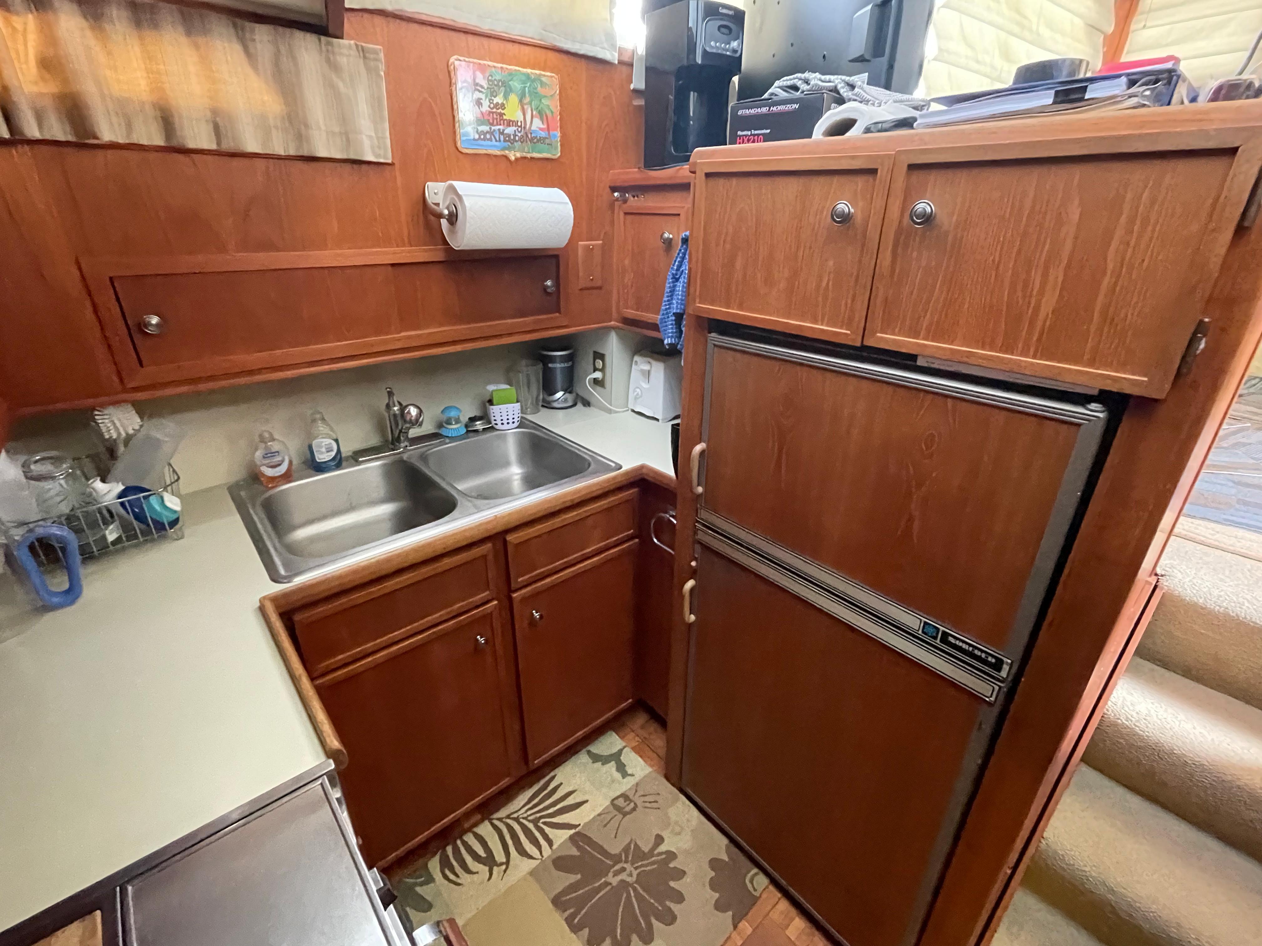 1975 Uniflite Aft Cabin kitchen with wood cabinets and double sink.