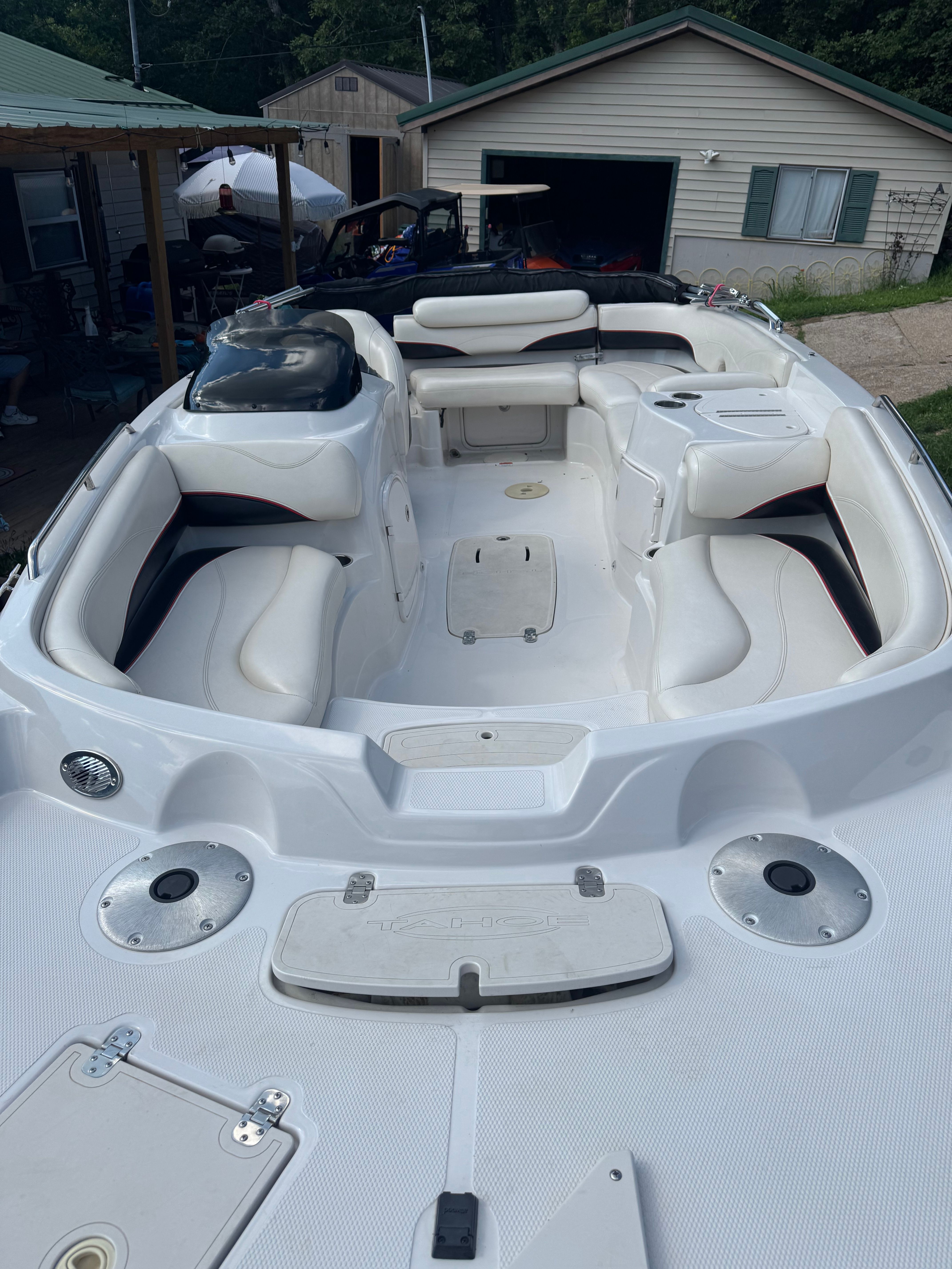 The image shows a white boat with cushioned seating and a spacious deck.