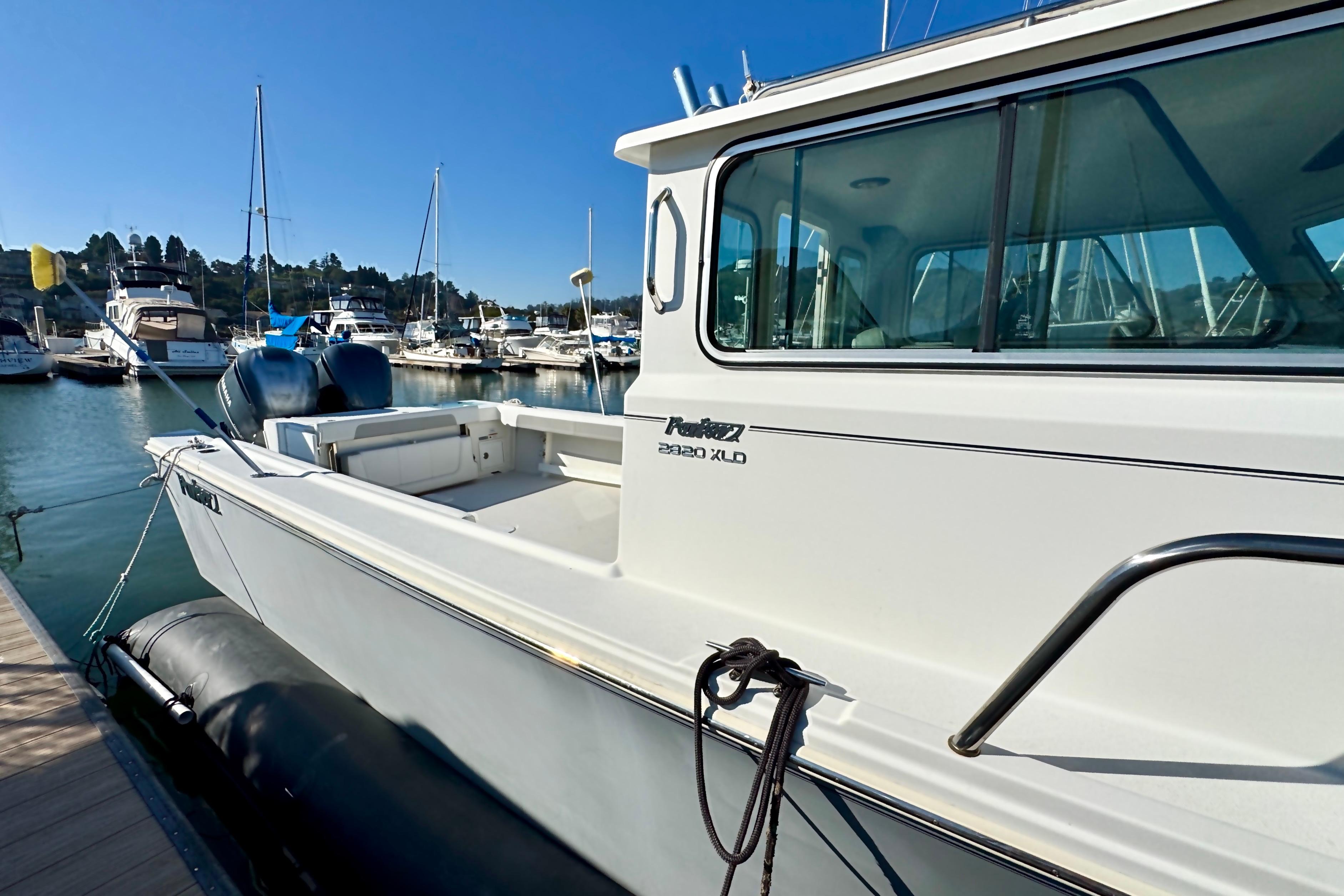 2021 Parker 2820 XLD Sport Cabin boat docked at marina under clear blue sky.