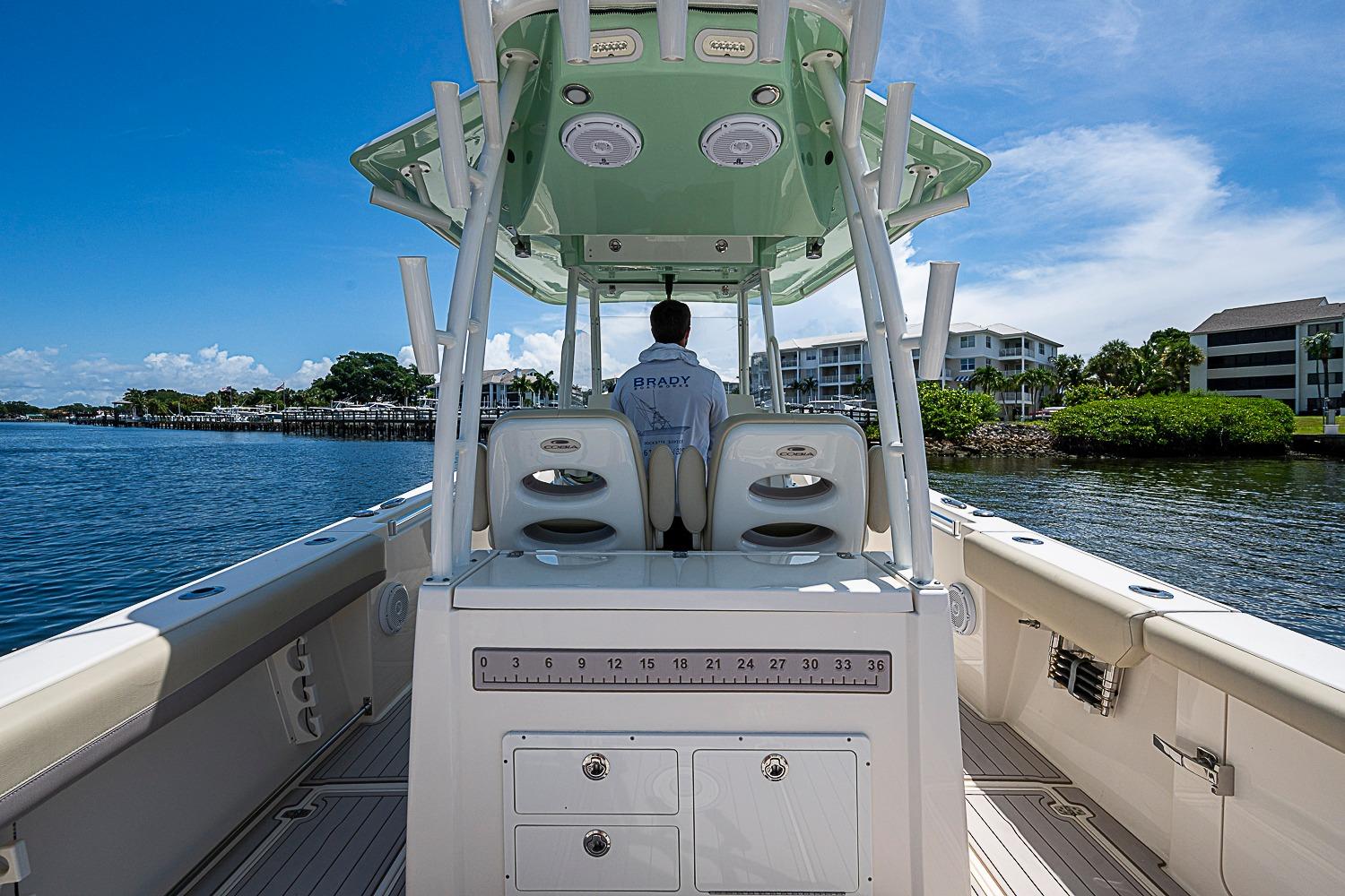 2019 Cobia 320 Center Console boat on calm water, featuring spacious deck and modern design.