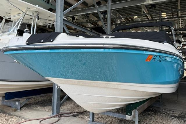 2022 Sea Ray SPX 210 Outboard boat in storage, blue hull, covered deck.