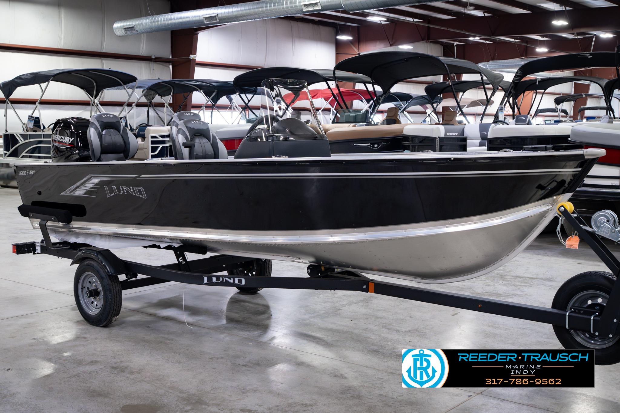 2026 Lund 1600 Fury SS boat on trailer in showroom, featuring Mercury engine.