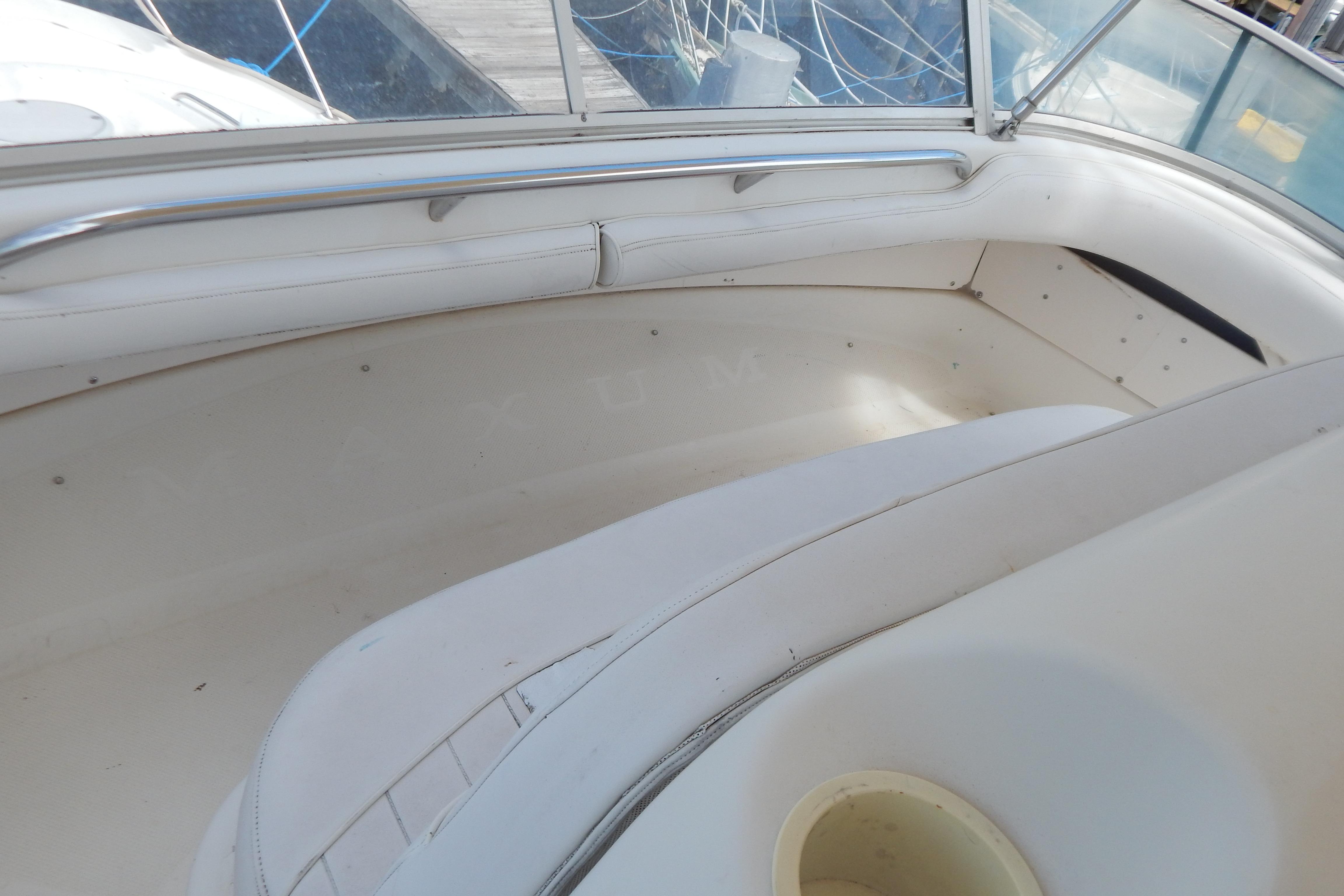 Interior seating of a 1998 Magnum 4100 SCR boat, featuring white upholstery and stainless steel railing.