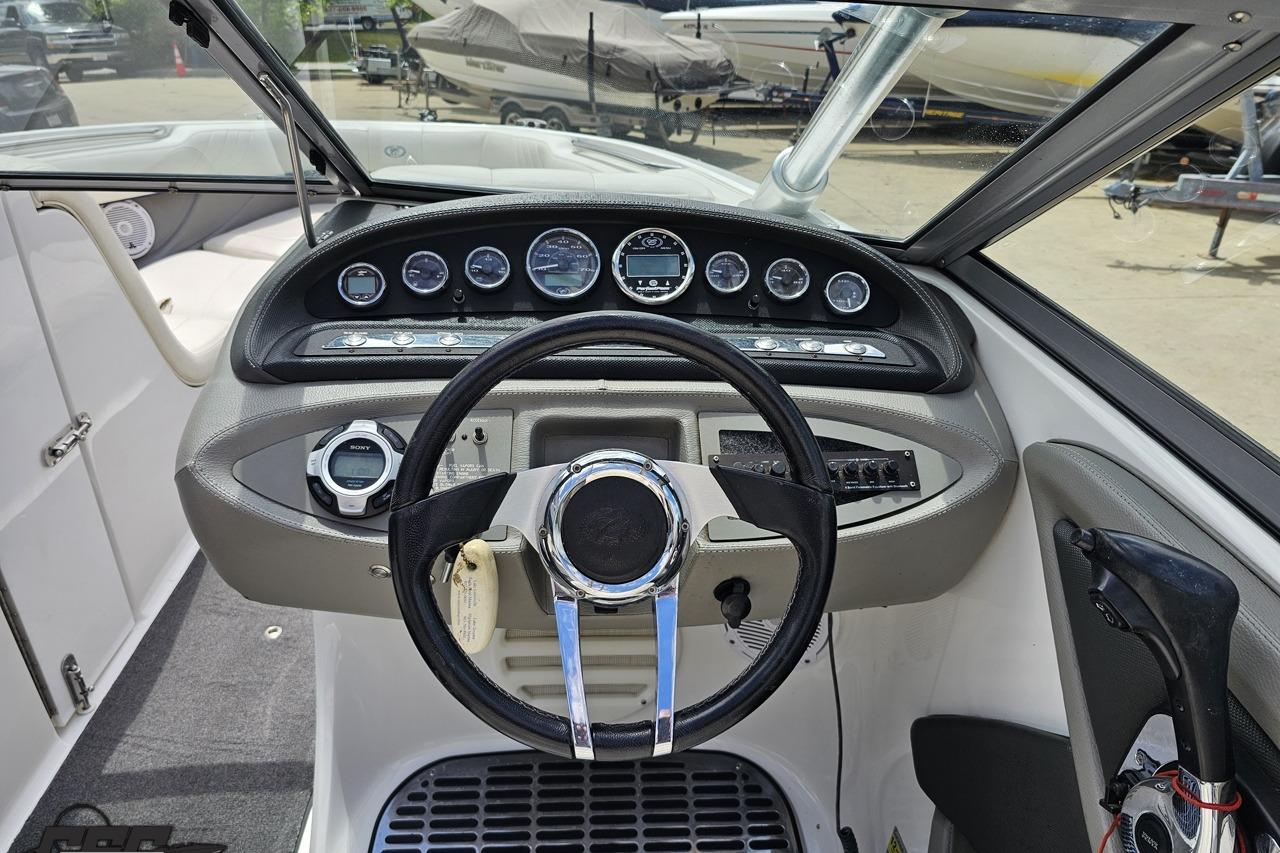 Steering console of a 2010 Cobalt 232 WSS boat with gauges and controls.
