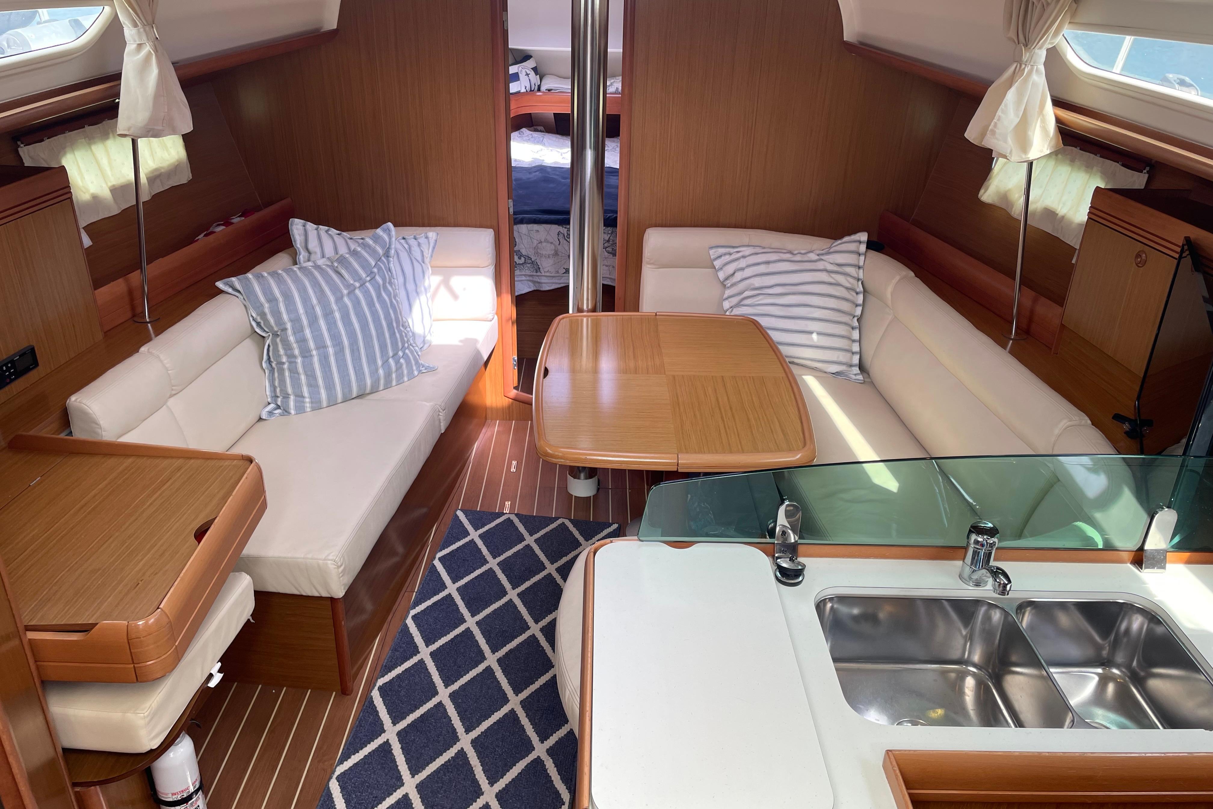 Interior of 2007 Jeanneau Sun Odyssey 39 DS yacht with cozy seating and modern kitchen.
