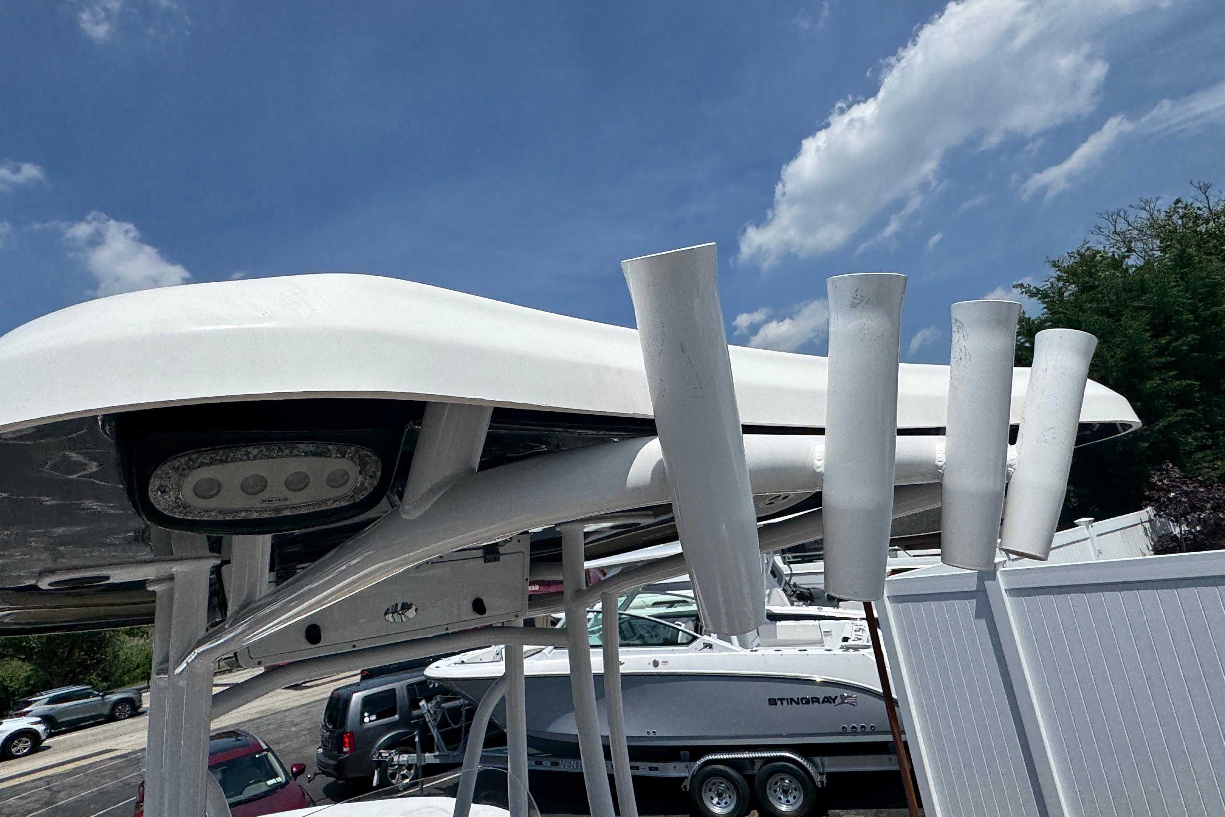 2016 Tidewater 230 LXF boat with rod holders and T-top under a clear blue sky.