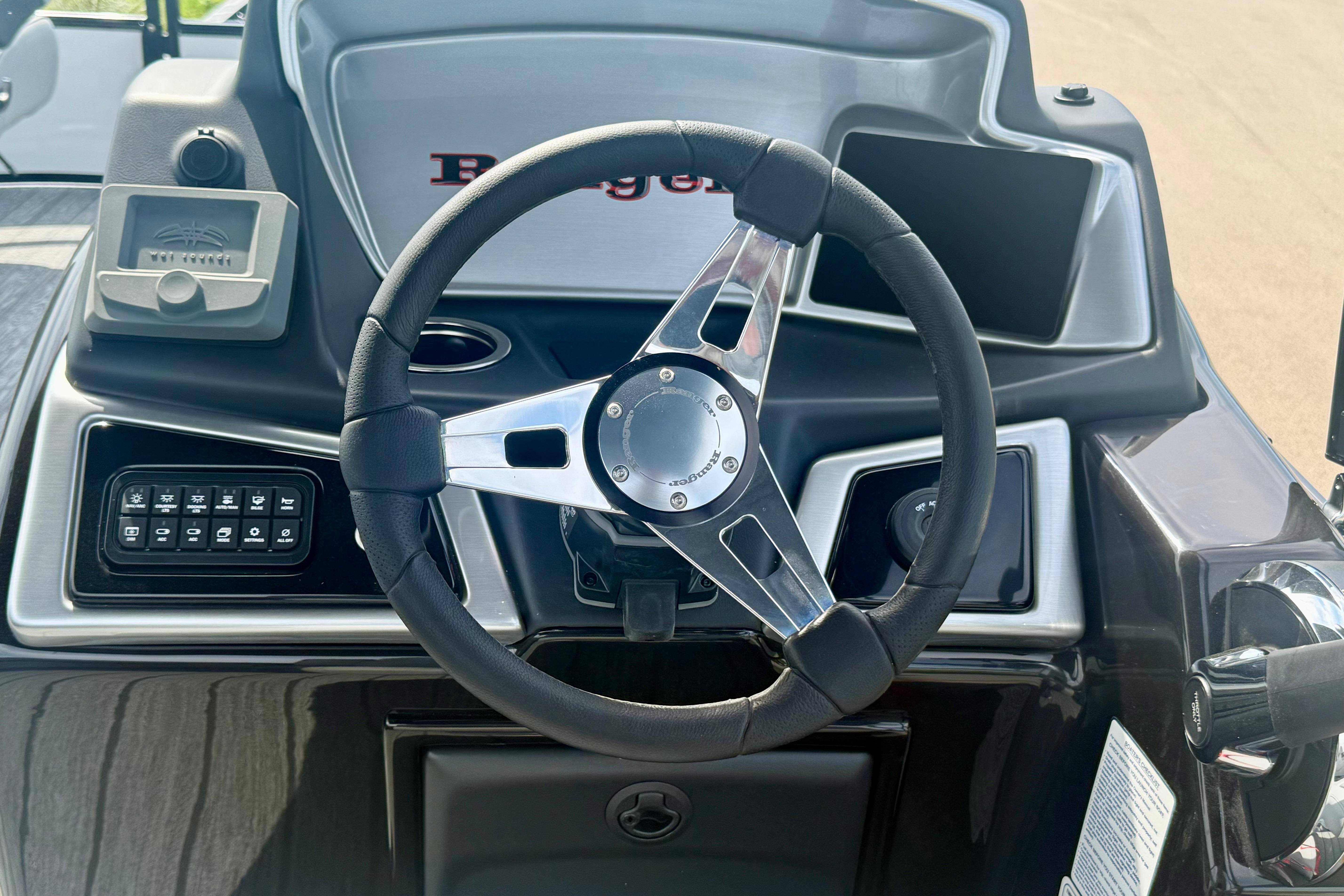 Steering wheel and dashboard of 2026 Ranger 223FC boat, featuring modern controls.