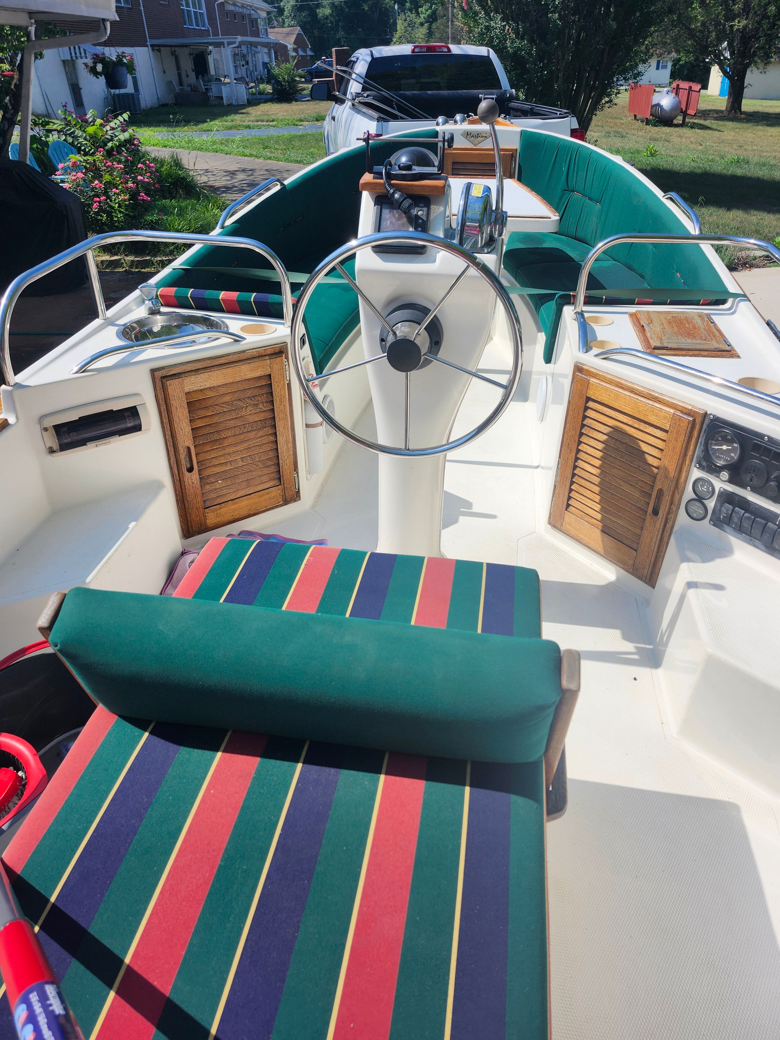 The boat features striped upholstery and wooden doors in the cockpit.