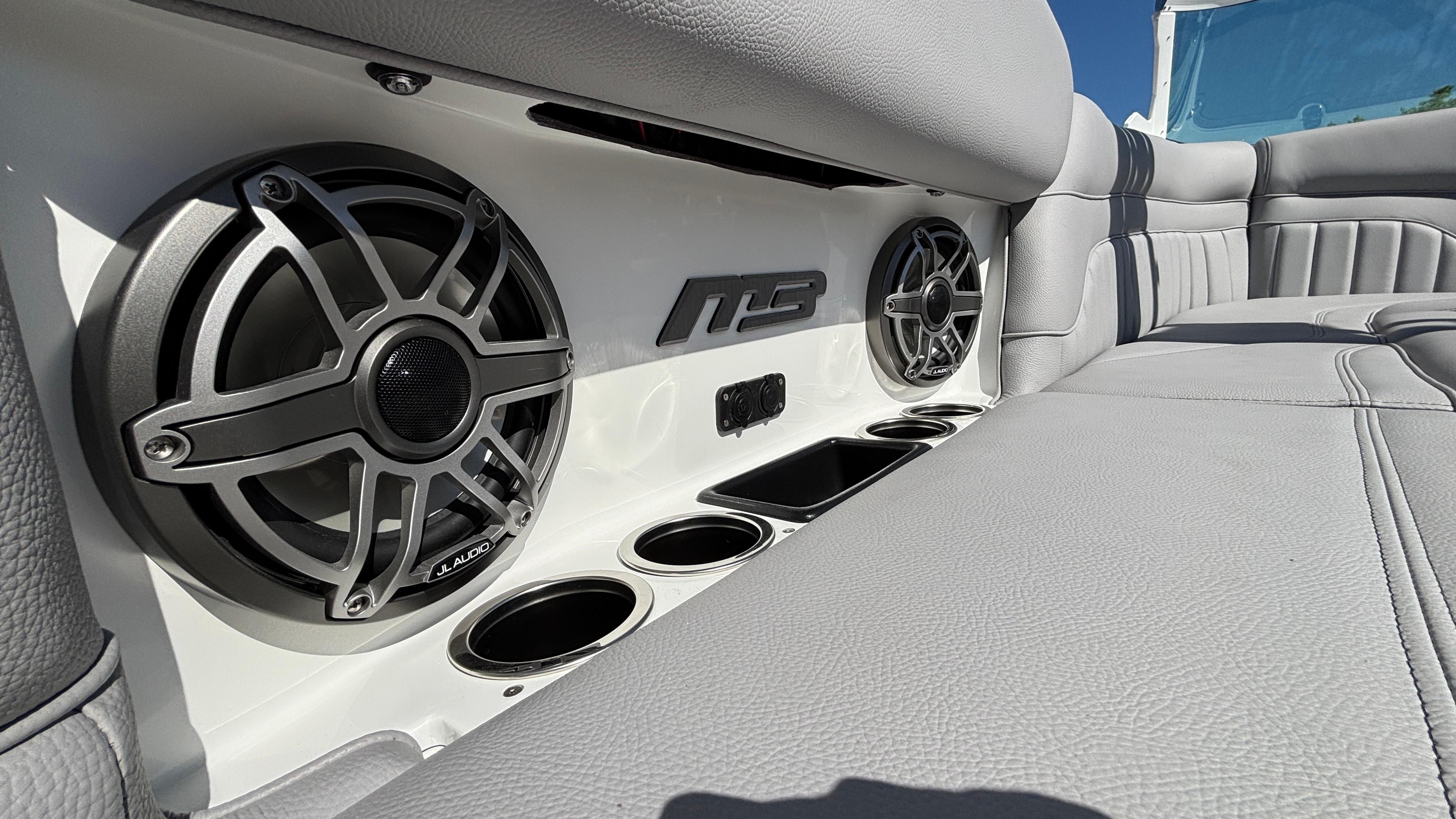 Luxury boat interior with JL Audio speakers, cup holders, and plush seating in MB B52 25 Alpha 2025.