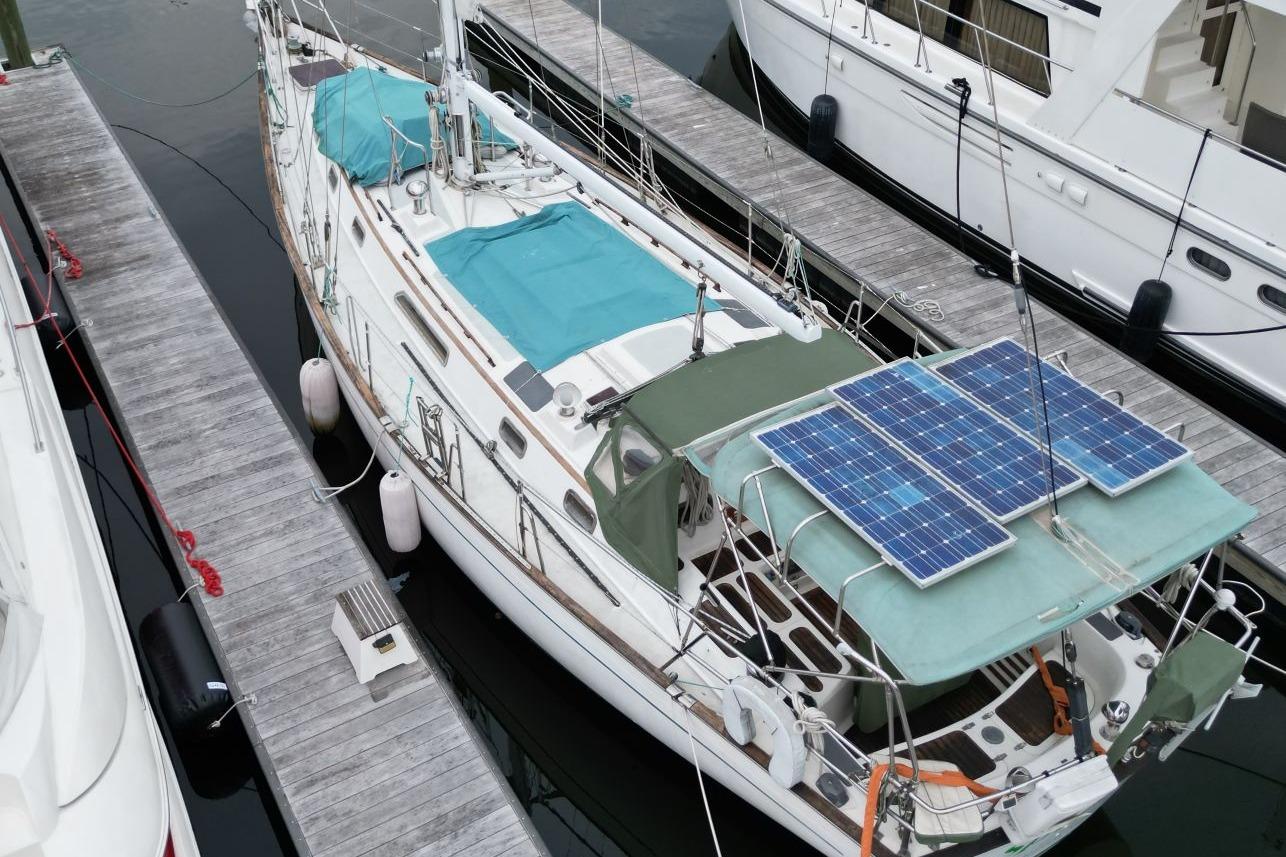 Sailboat docked with solar panels, Passport 47 model, 1985, aerial view.