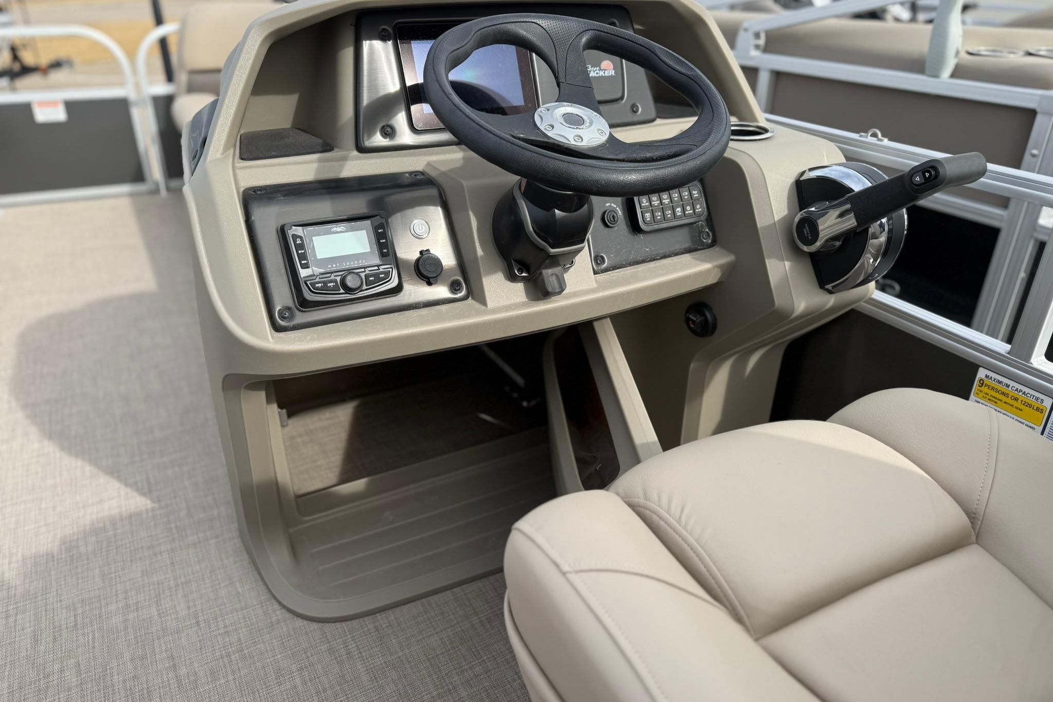 2025 Sun Tracker Party Barge 18 DLX helm with steering wheel and control panel.