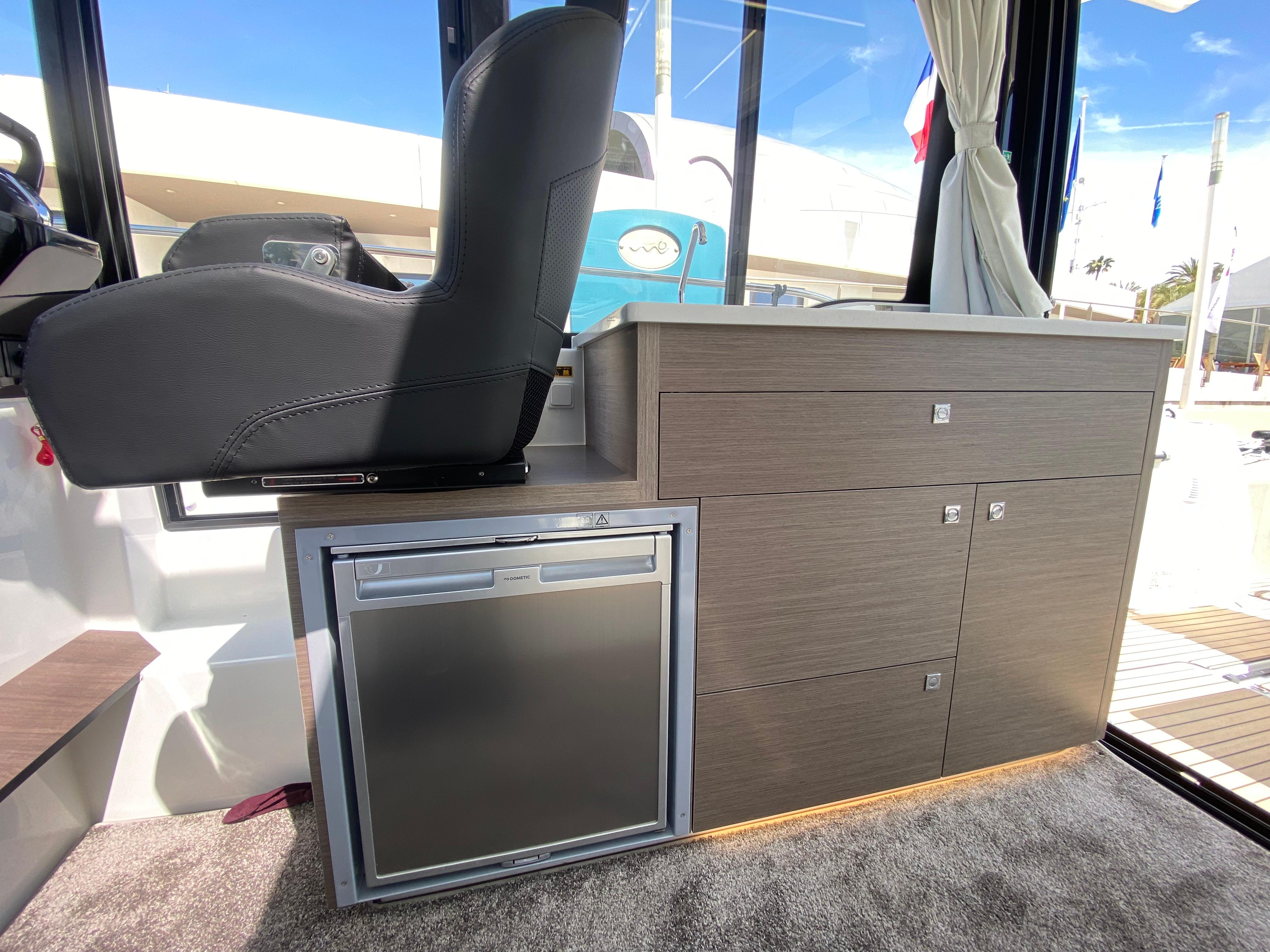 Interior of 2025 Jeanneau MERRY FISHER 895 S2 with seating and compact kitchenette.