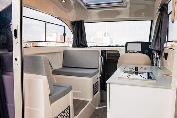 Interior of 2026 Trophy T25EX EXPLORER OB boat with seating and kitchenette.