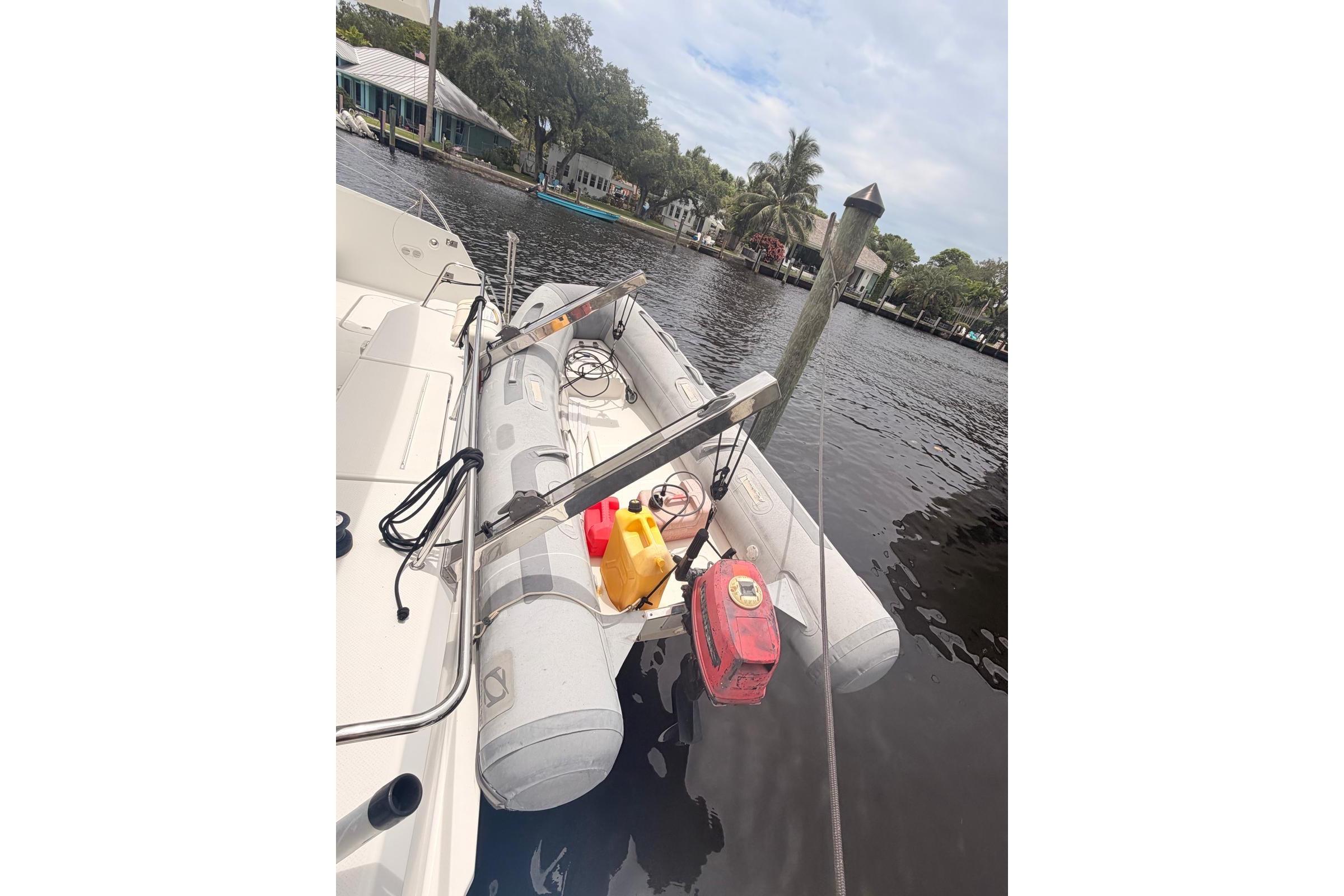 Inflatable dinghy on 2018 Fountaine Pajot Lucia 40 catamaran, docked by a serene waterfront.