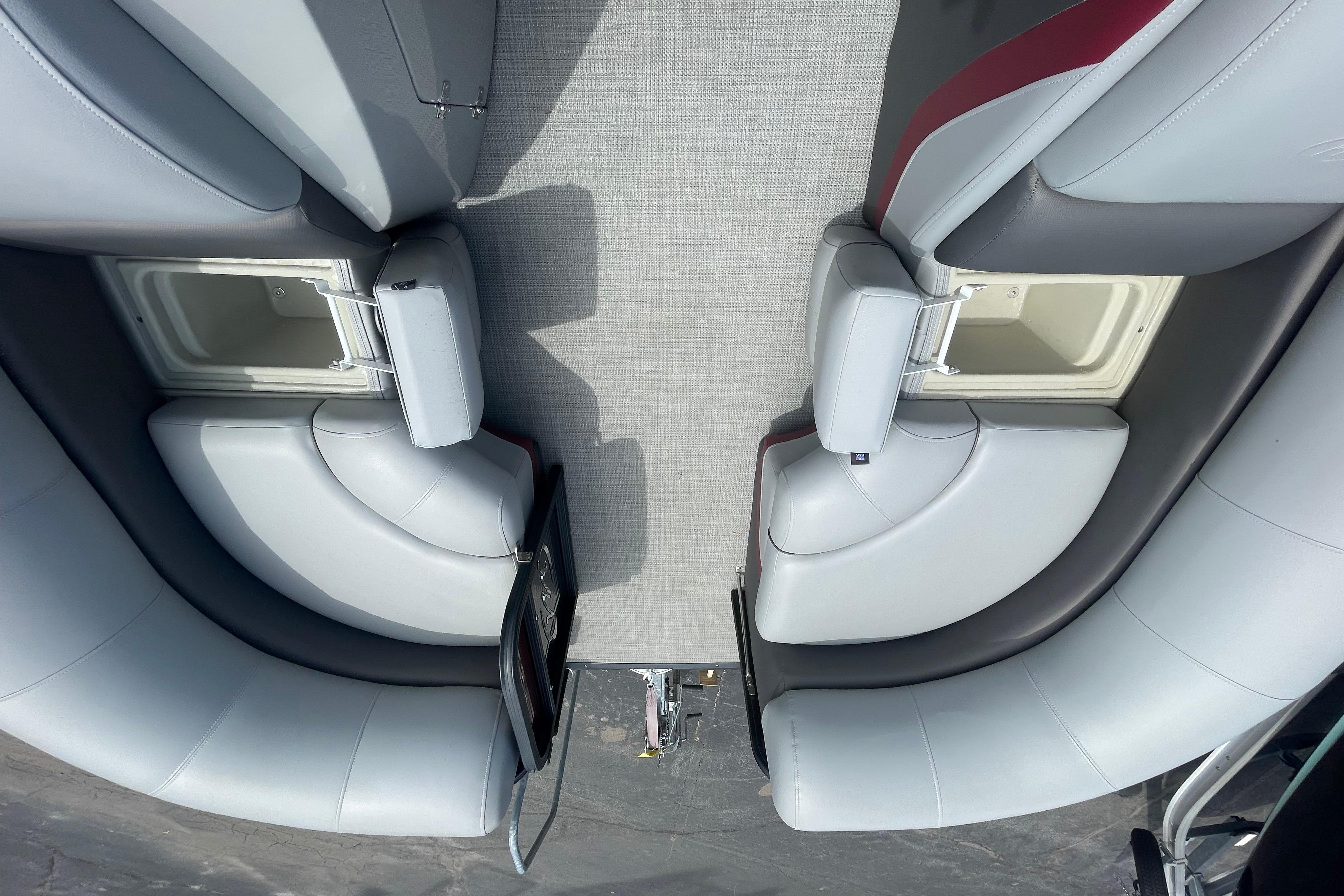 Interior view of 2022 Manitou 23 Oasis boat with gray seating and storage compartments.