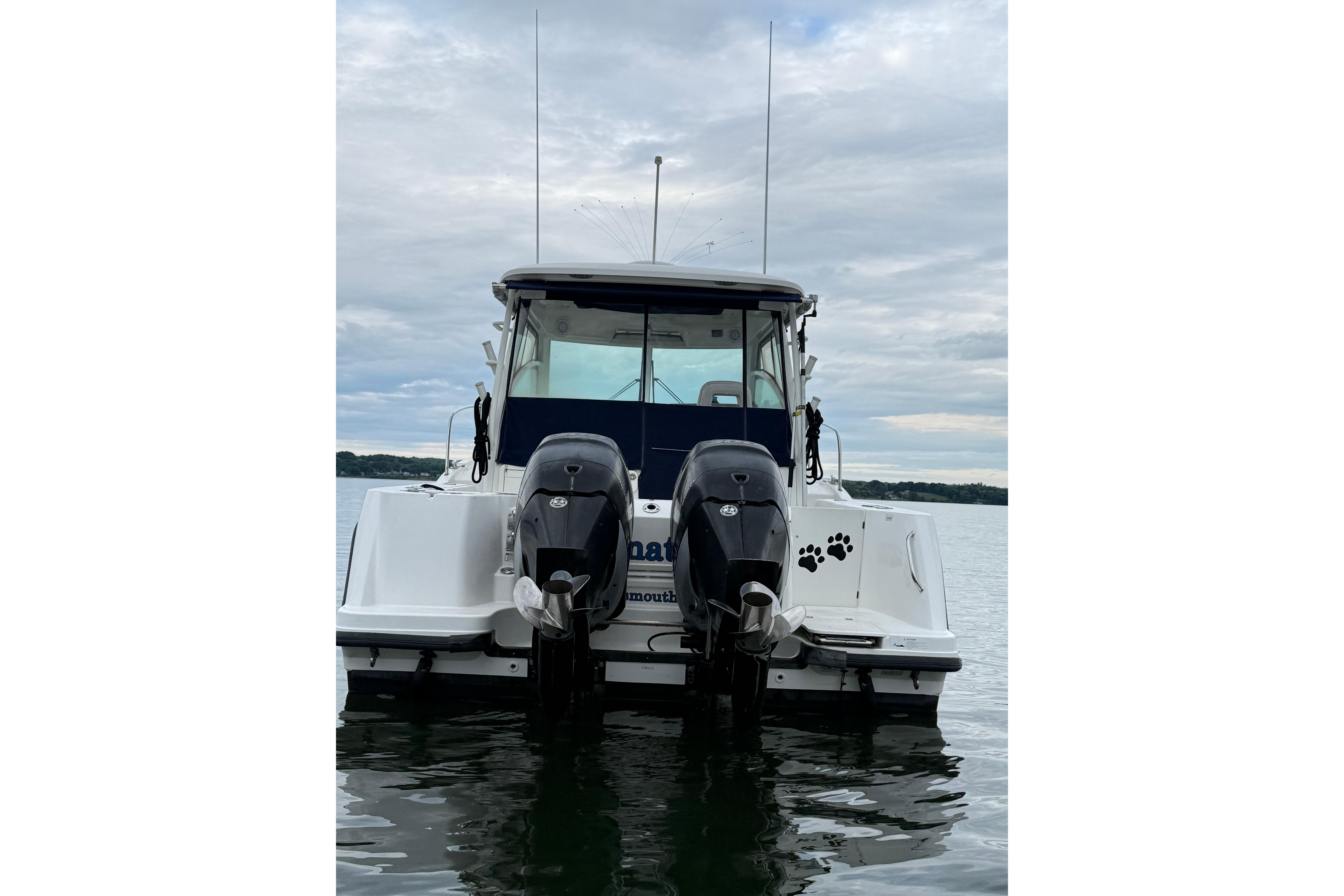 2013 Boston Whaler 315 Conquest boat with twin outboard motors on calm water.