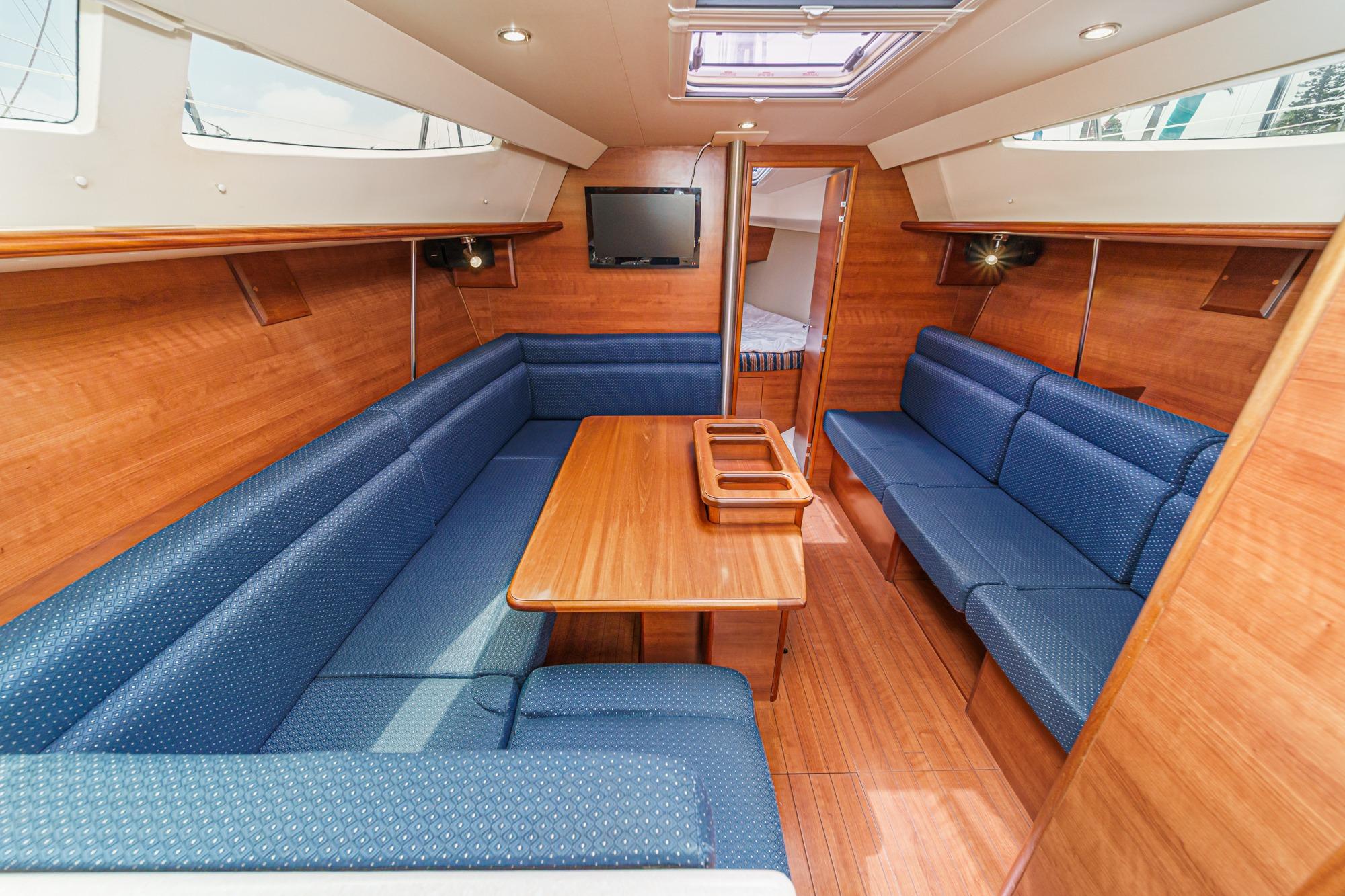 Interior of a 2015 Hunter 33 sailboat with blue seating and wooden finishes.