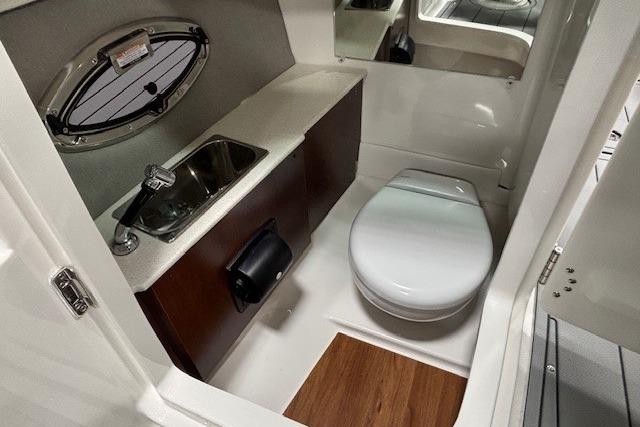 2026 Chaparral SSX 8 boat interior with compact bathroom, featuring sink and toilet.