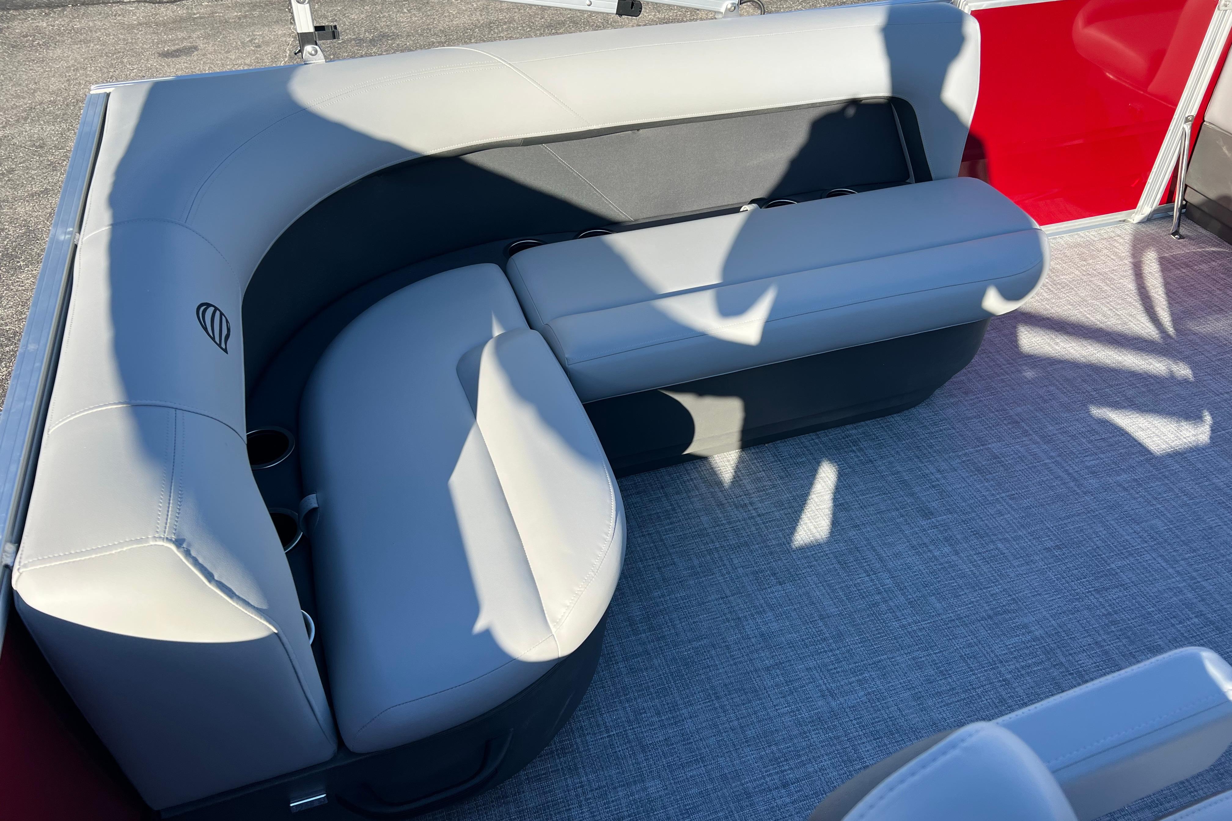 2026 Sun Tracker Party Barge 16 DLX interior seating with gray upholstery and cup holders.